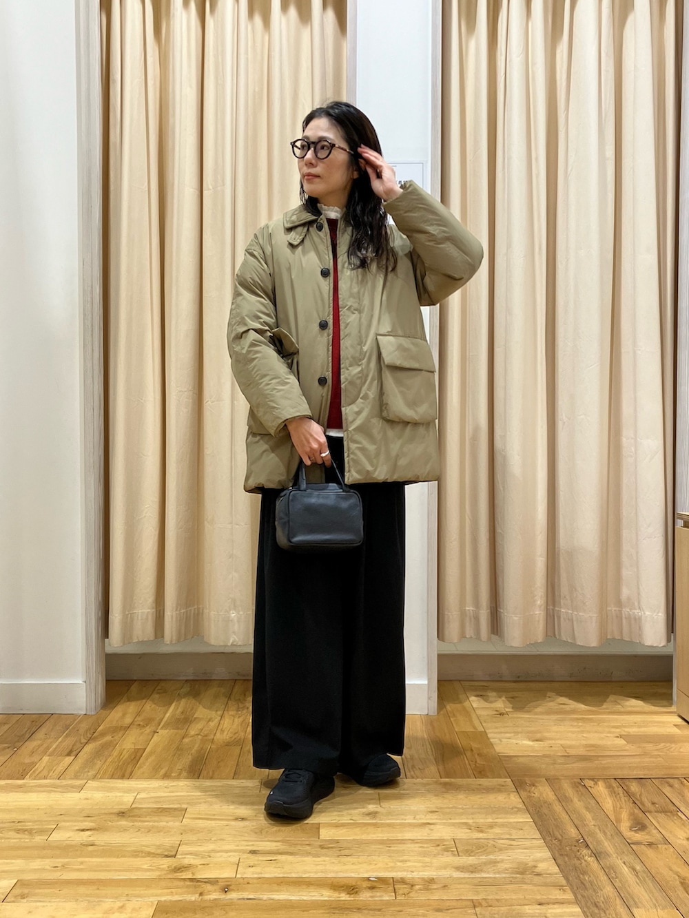 ブラック系のその他パンツ、ブラック系のボストンバッグ、ホワイト系のシャツ/ブラウスを着用したレディースの冬コーディネートの2枚目の写真