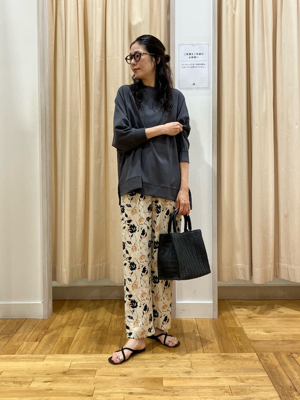 グレー系のTシャツ/カットソー、ベージュ系のその他パンツ、ブラック系のハンドバッグを着用したレディースの春コーディネートの2枚目の写真