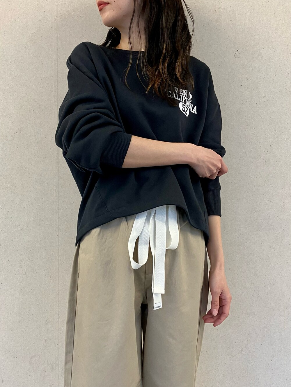 ブルー系のスウェット、ベージュ系のチノパンツ、ホワイト系のバレエシューズを着用したレディースの春コーディネートの5枚目の写真