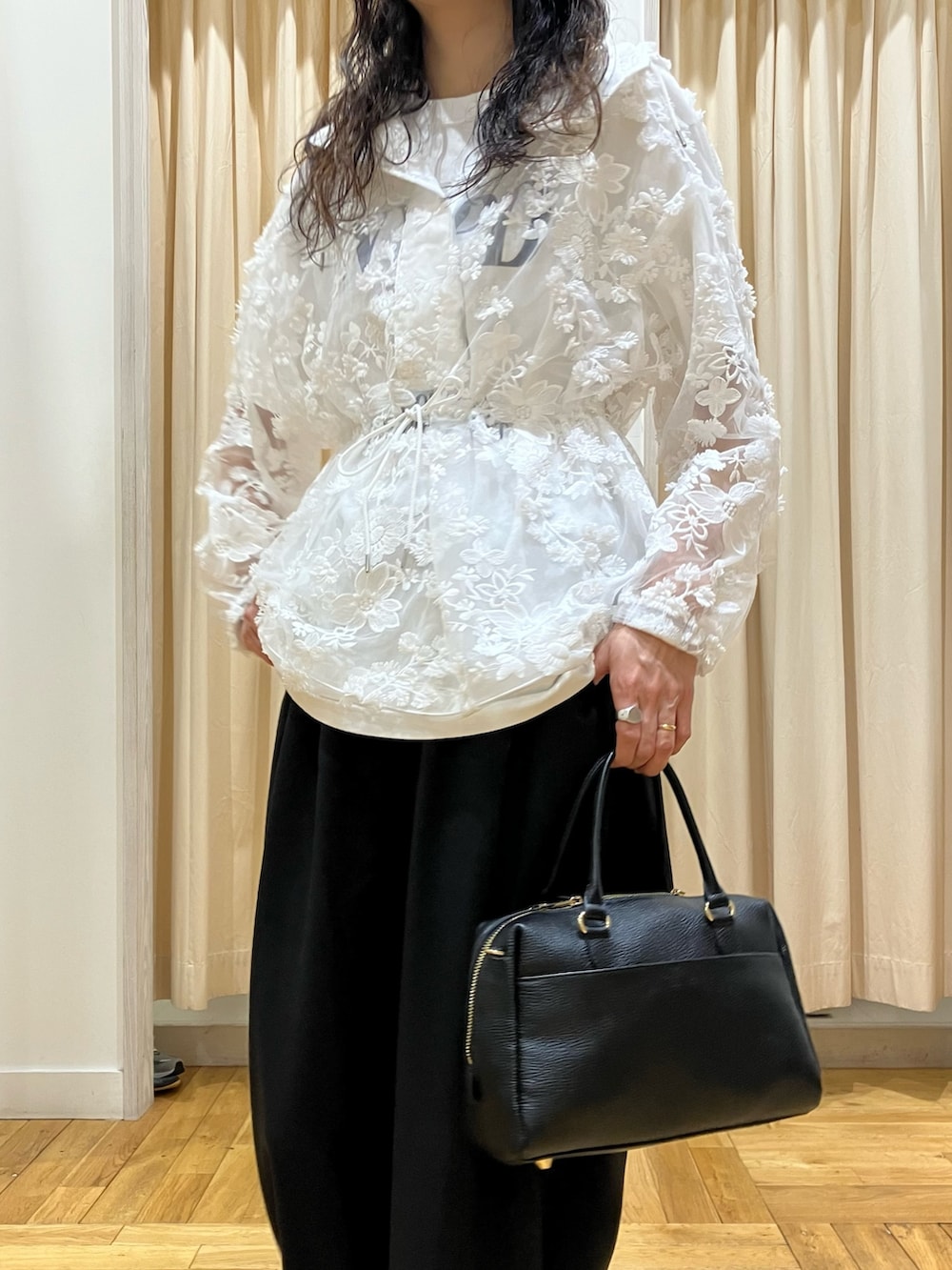 ホワイト系のパーカー、グレー系のスニーカー、ブラック系のその他パンツを着用したレディースの春コーディネートの4枚目の写真