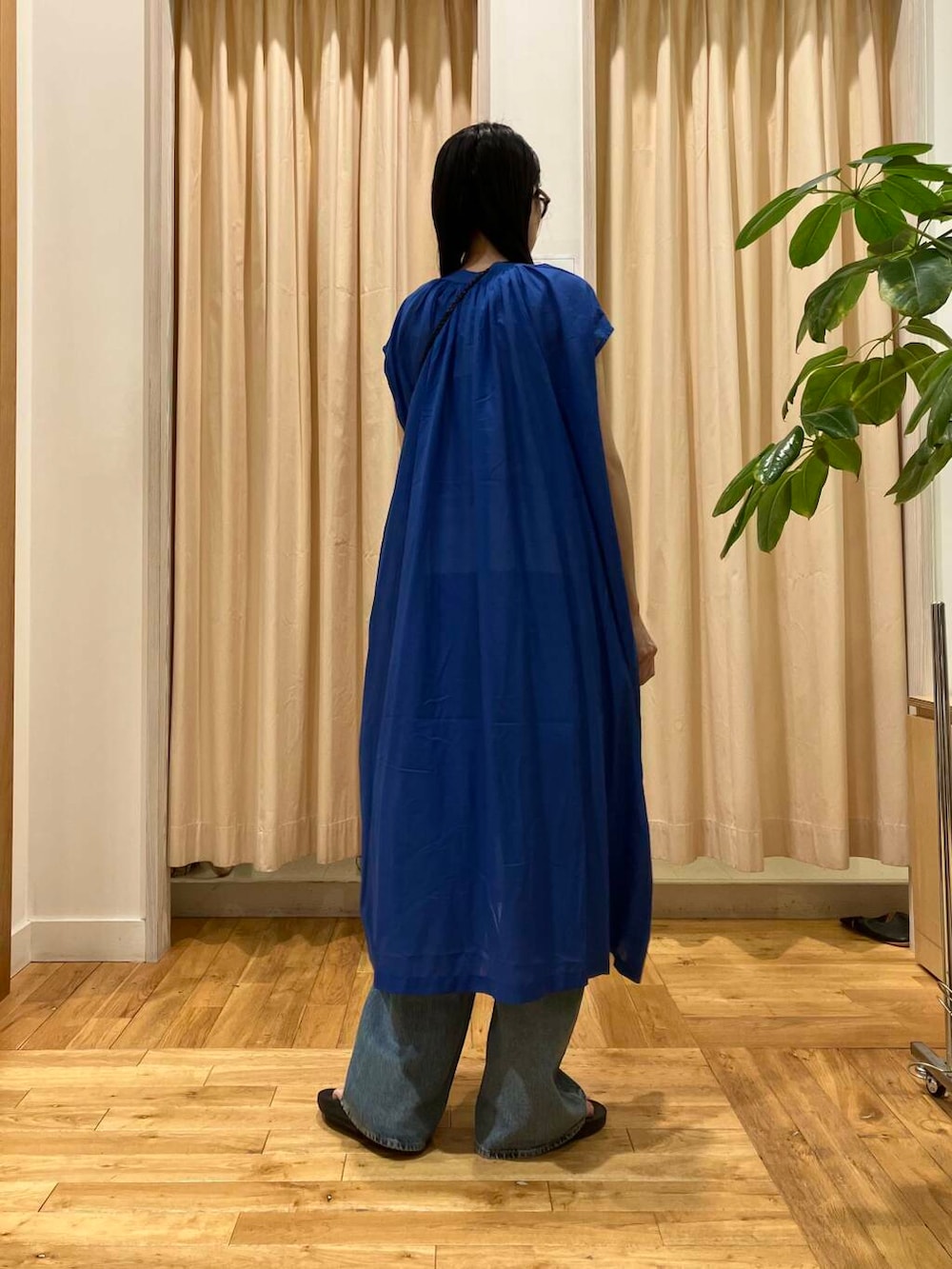 ブルー系のデニムパンツ、ブラック系のサンダル、ホワイト系のタンクトップを着用したレディースの夏コーディネートの4枚目の写真