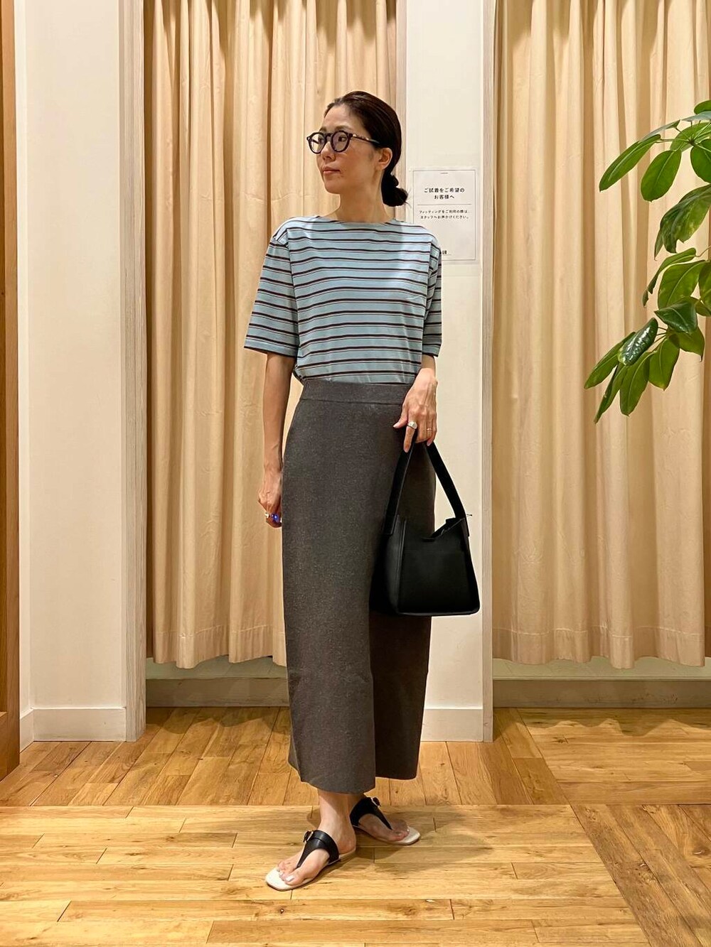 ブラック系のサンダル、グレー系のスカート、ブルー系のTシャツ/カットソーを着用したレディースの夏コーディネートの2枚目の写真