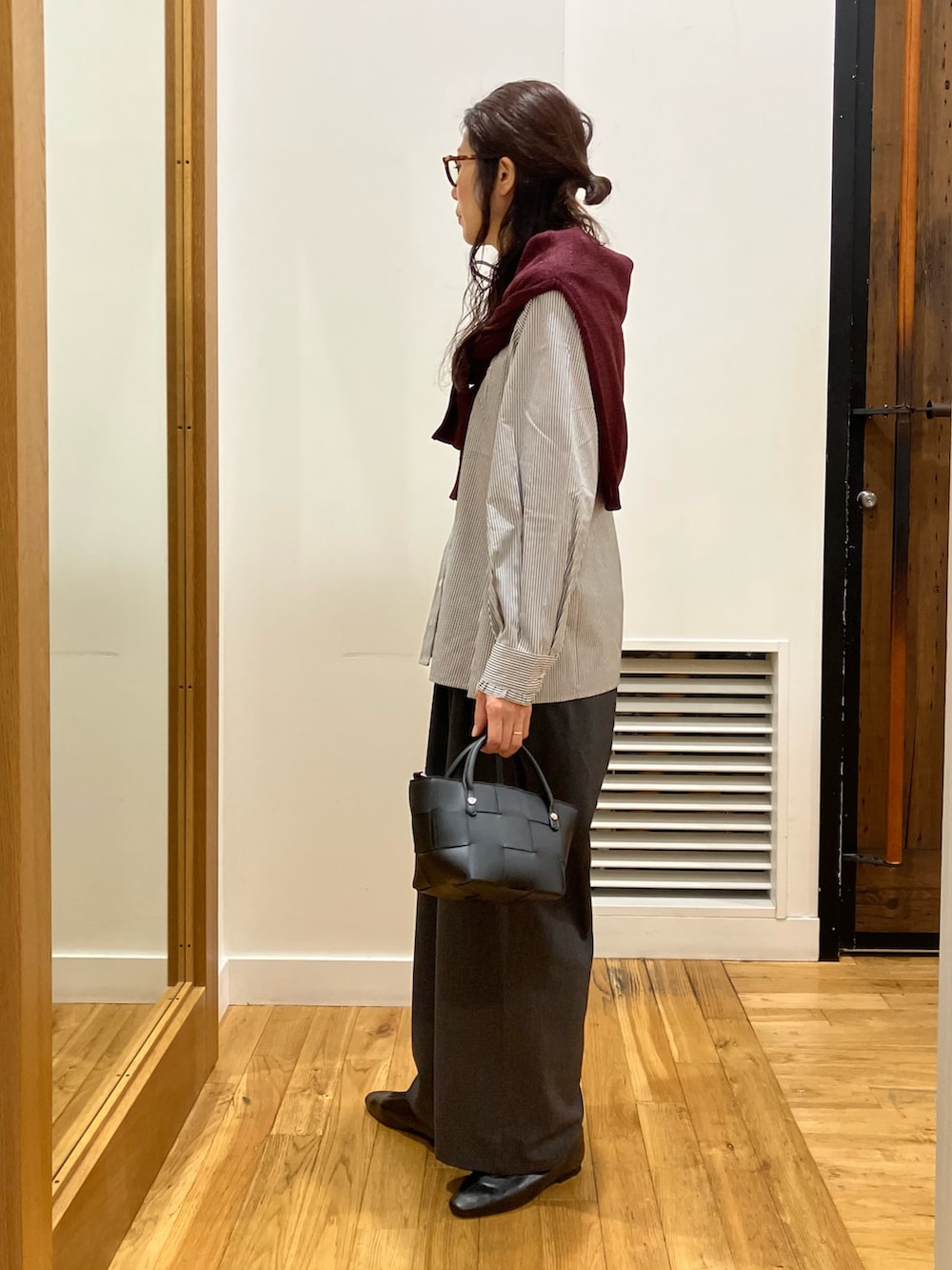 ブラック系のシャツ/ブラウス、レッド系のカーディガン/ボレロ、ブラック系のハンドバッグを着用したレディースの秋コーディネートの3枚目の写真