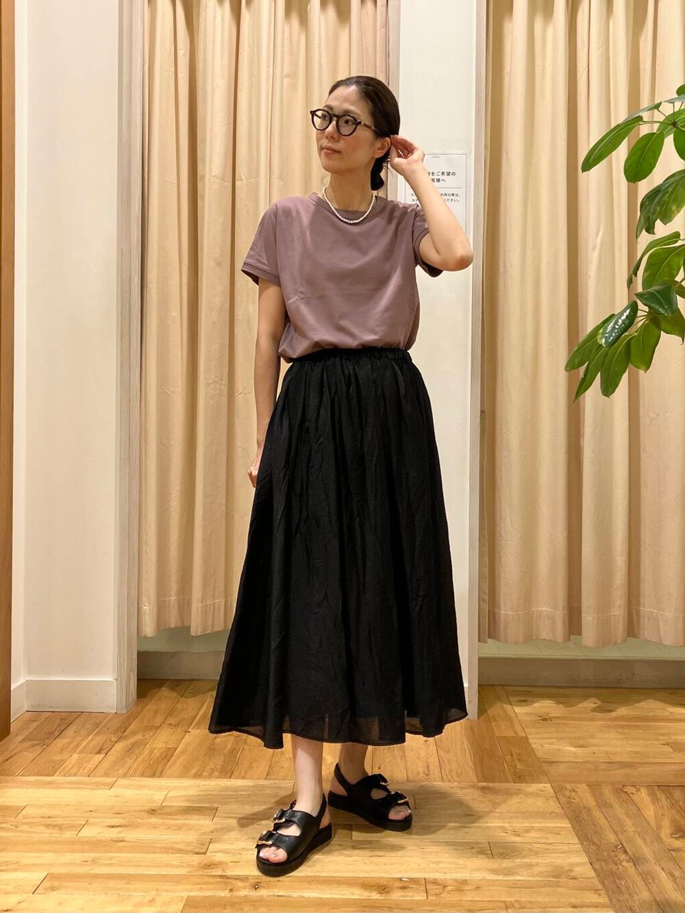 ブラック系のスカート、レッド系のTシャツ/カットソー、ブラック系のサンダルを着用したレディースの夏コーディネートの2枚目の写真