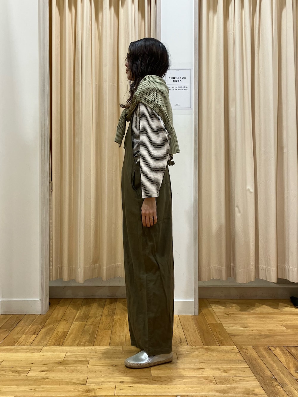 グリーン系のサロペット/オーバーオール、ベージュ系のTシャツ/カットソー、グリーン系のニット/セーターを着用したレディースの春コーディネートの3枚目の写真