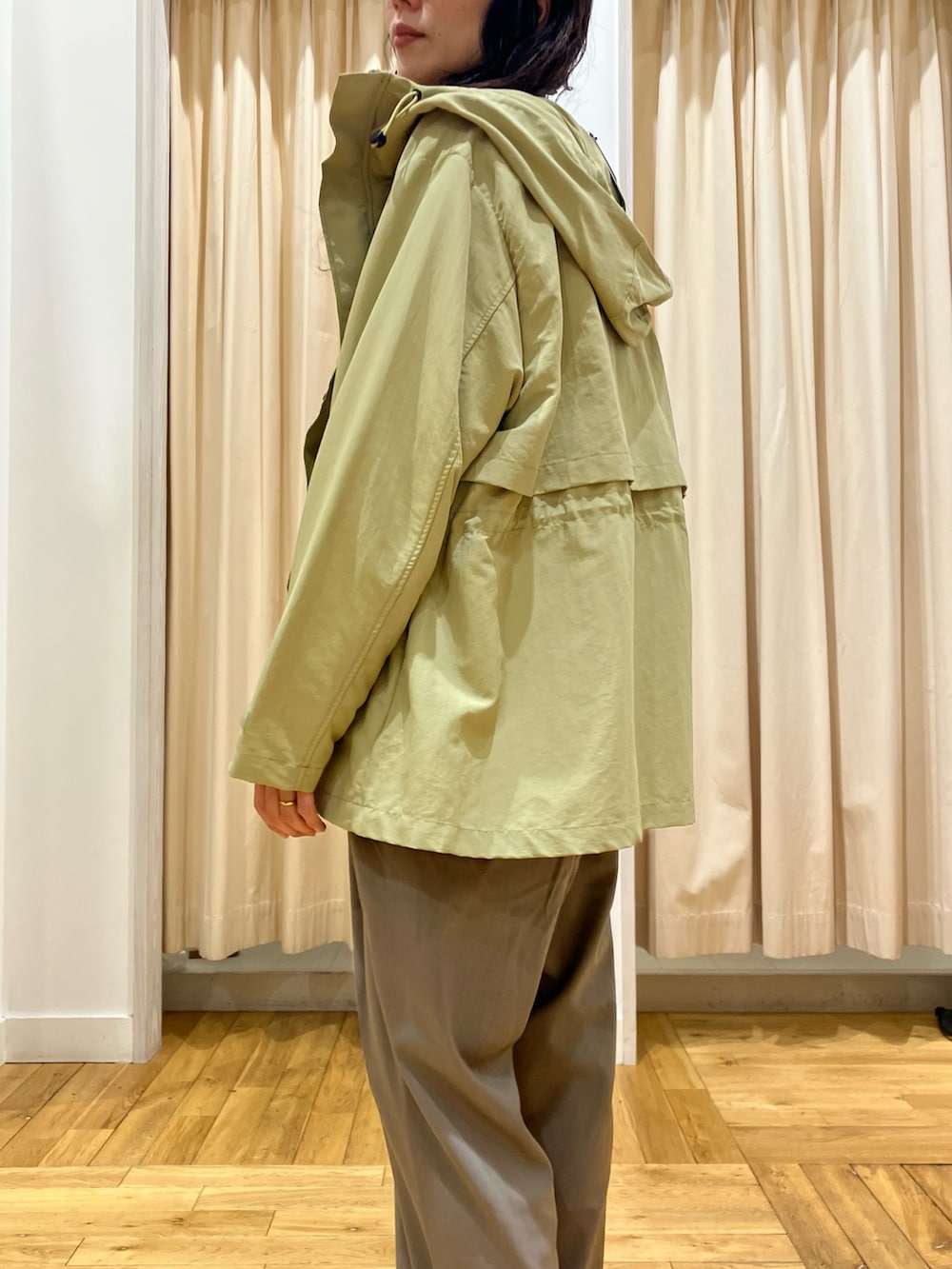 ホワイト系のニット/セーター、グリーン系のマウンテンパーカー、グレー系のその他パンツを着用したレディースの春コーディネートの5枚目の写真