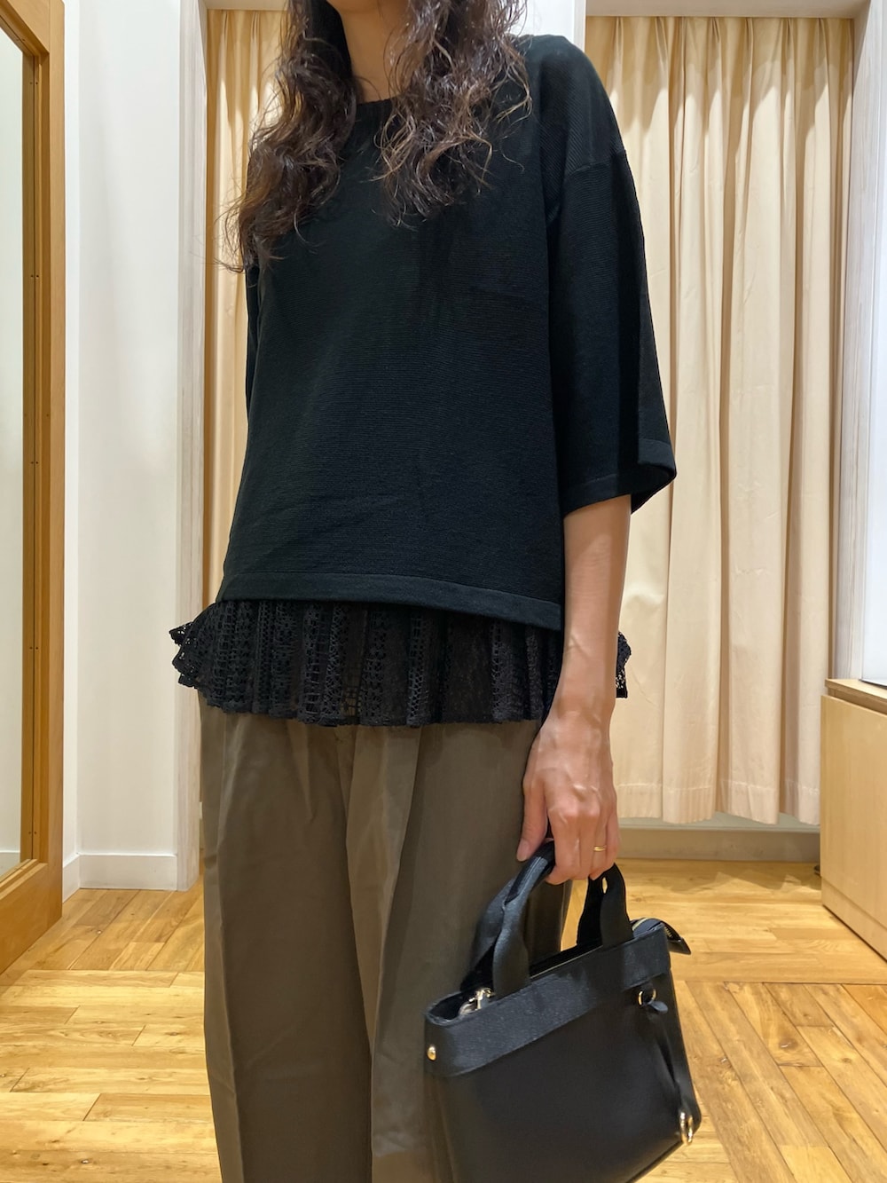 ブラック系のニット/セーター、ブラック系のパンプス、グリーン系のその他パンツを着用したレディースの秋コーディネートの4枚目の写真