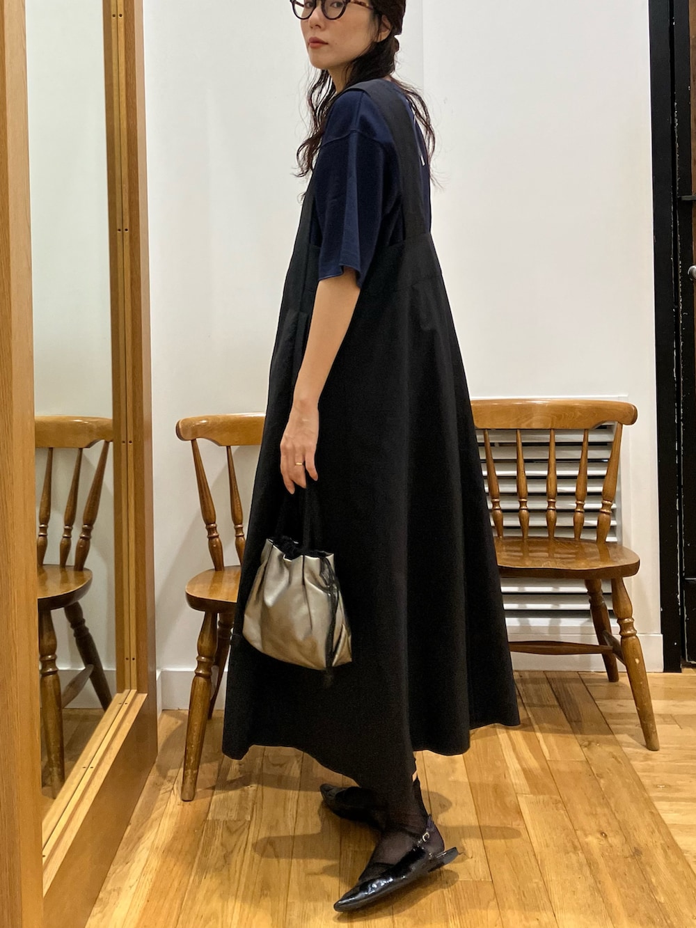 ブルー系のTシャツ/カットソー、ブラック系のワンピース、シルバー系のショルダーバッグを着用したレディースの秋コーディネートの2枚目の写真