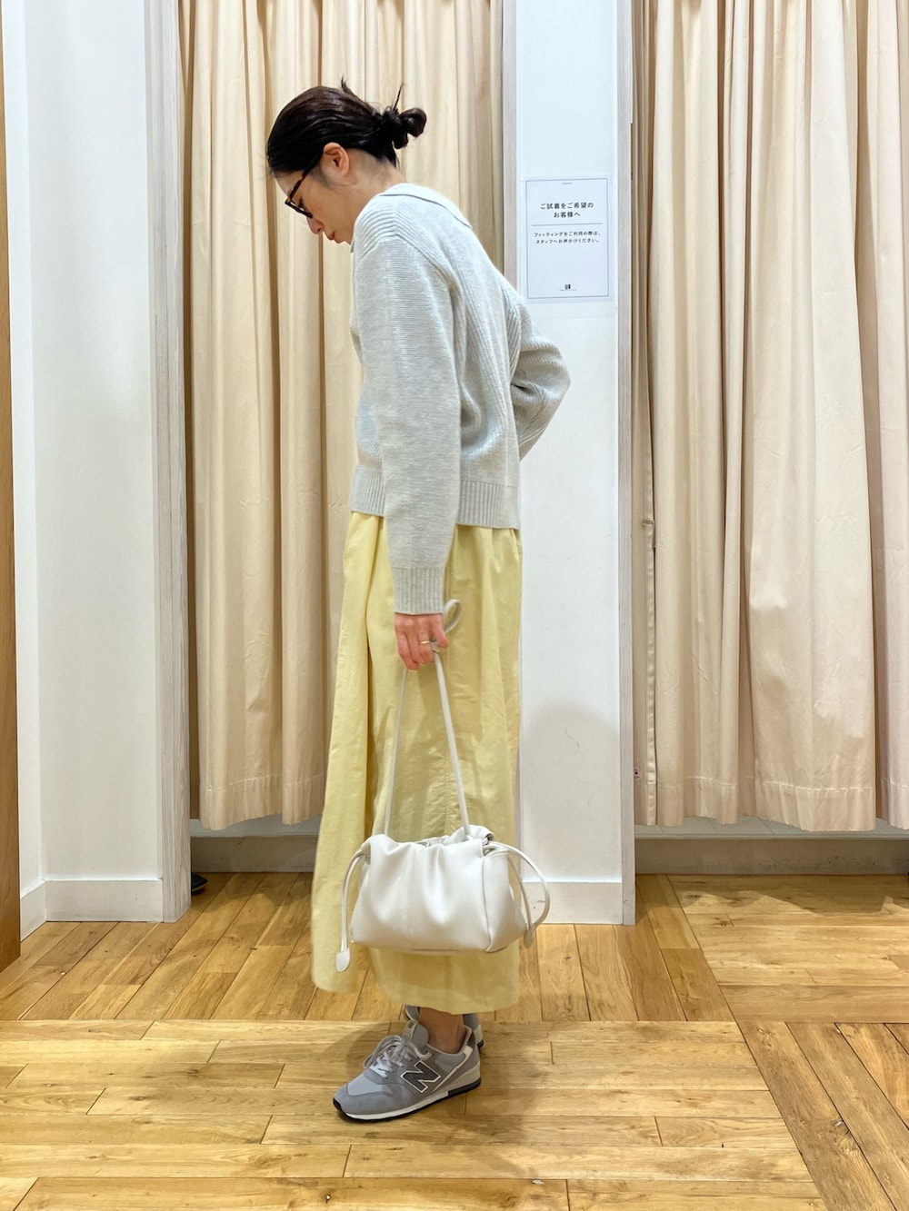 グレー系のニット/セーター、イエロー系のスカート、グレー系のスニーカーを着用したレディースの冬コーディネートの3枚目の写真