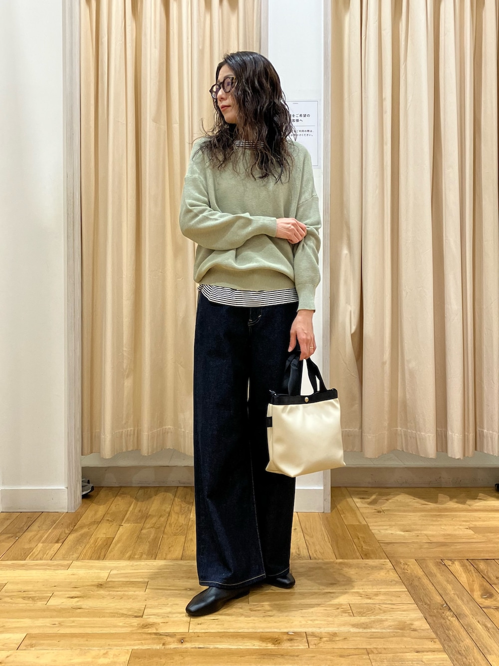 グリーン系のニット/セーター、ベージュ系のステンカラーコート、ブラック系のその他シューズを着用したレディースの春コーディネートの5枚目の写真