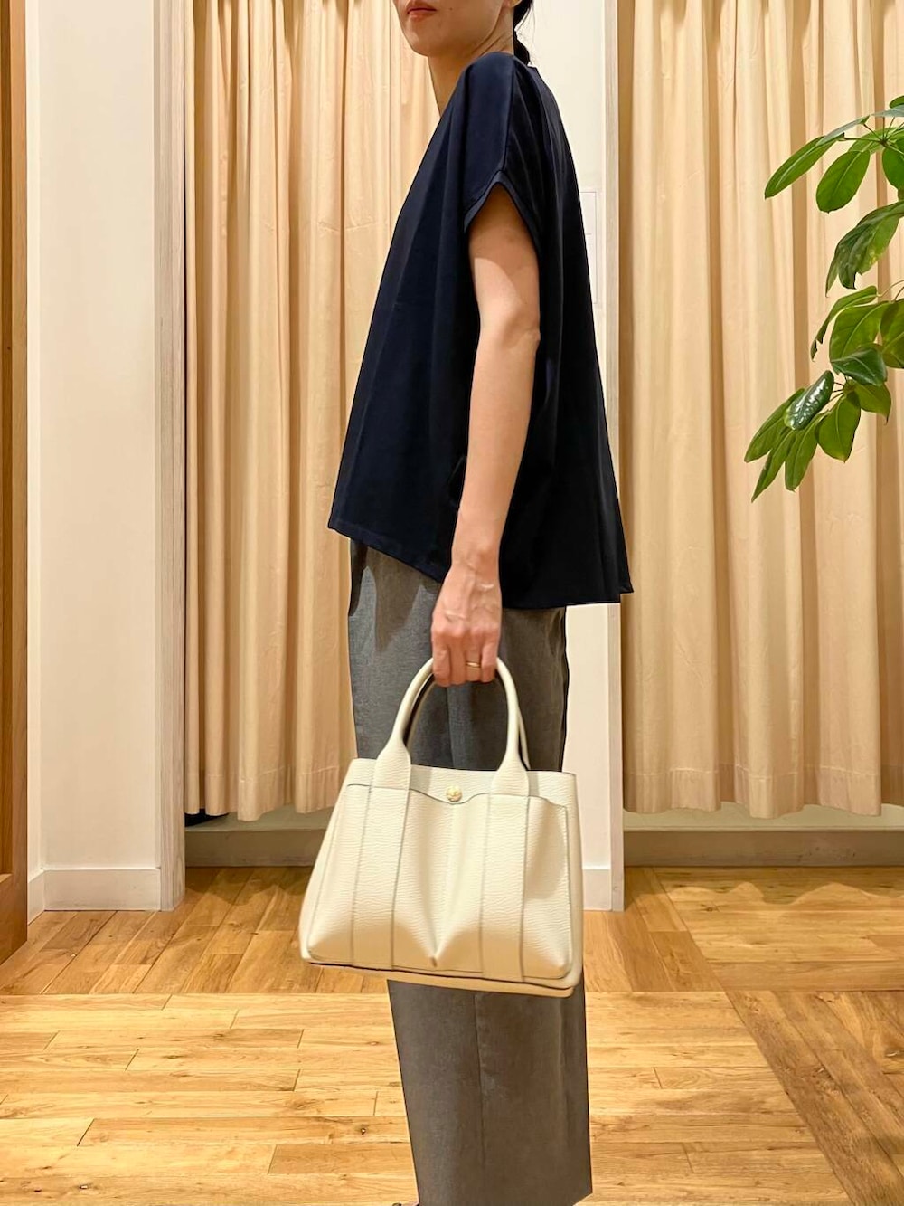 ホワイト系のトートバッグ、グレー系のその他パンツ、ブラック系のサンダルを着用したレディースの夏コーディネートの5枚目の写真