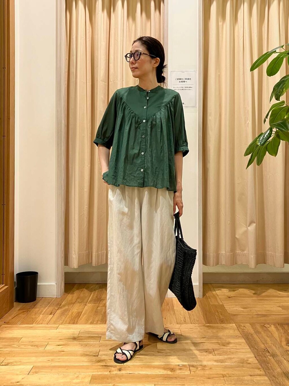 ブラック系のトートバッグ、ホワイト系のサンダル、ベージュ系のその他パンツを着用したレディースの夏コーディネートの2枚目の写真