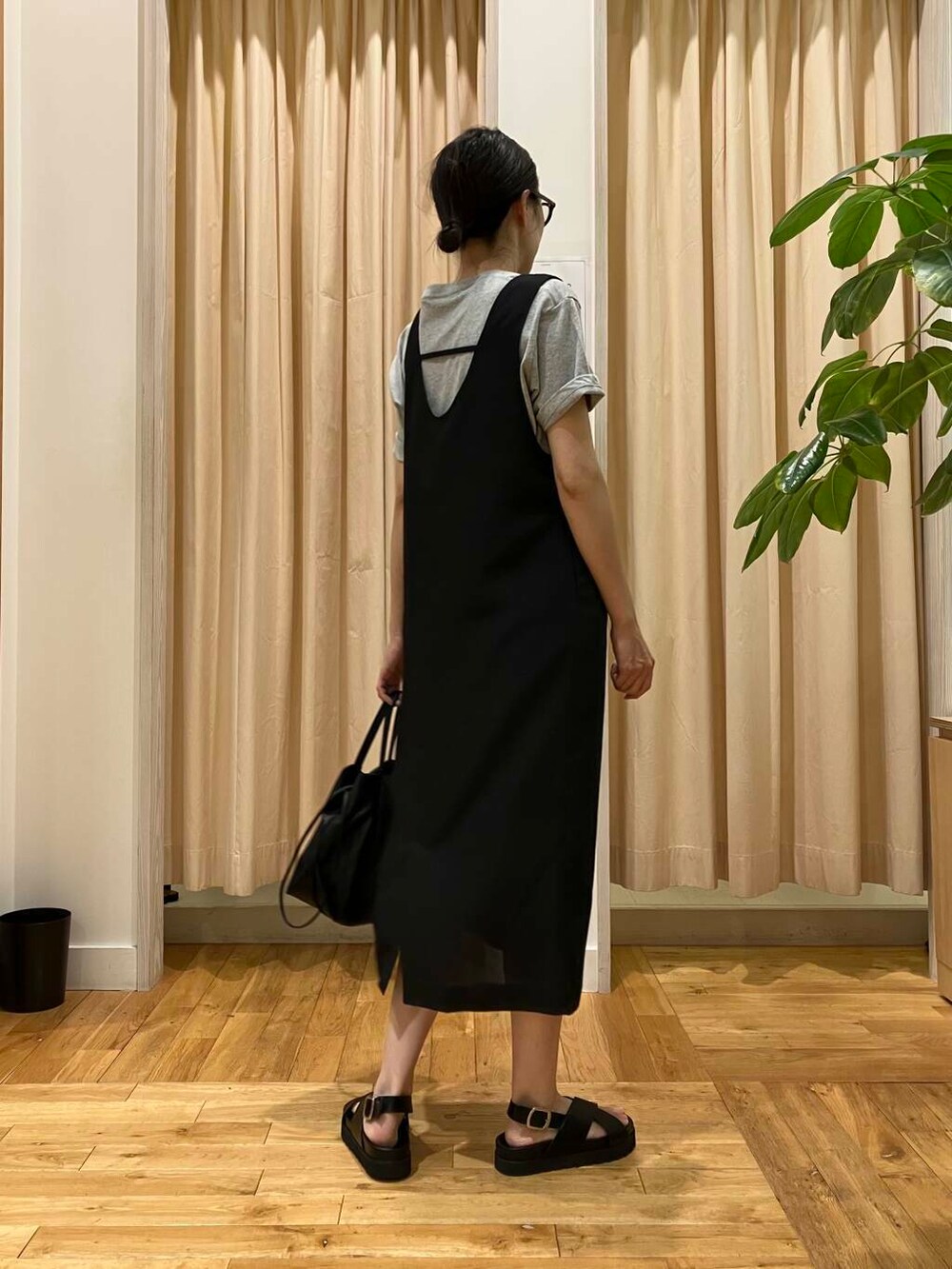 ブラック系のショルダーバッグ、ブラック系のサンダル、グレー系のTシャツ/カットソーを着用したレディースの夏コーディネートの3枚目の写真