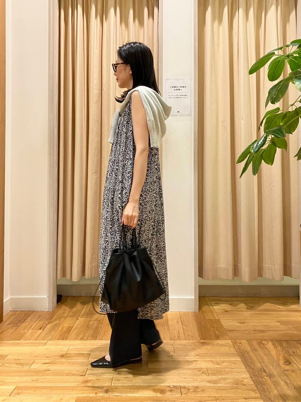 ブラック系のショルダーバッグ、グレー系のカーディガン/ボレロ、ブラック系のワンピースを着用したレディースの夏コーディネートの2枚目の写真