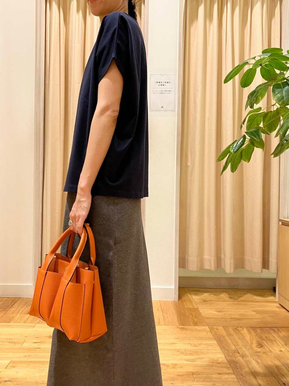 ブルー系のTシャツ/カットソー、グレー系のスカート、オレンジ系のトートバッグを着用したレディースの夏コーディネートの4枚目の写真