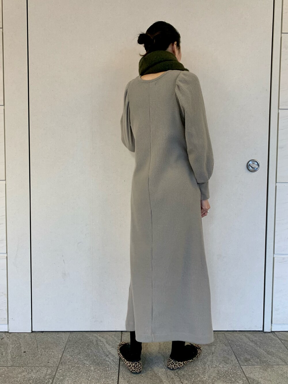 グレー系のワンピース、グリーン系のマフラーを着用したレディースの冬コーディネートの3枚目の写真