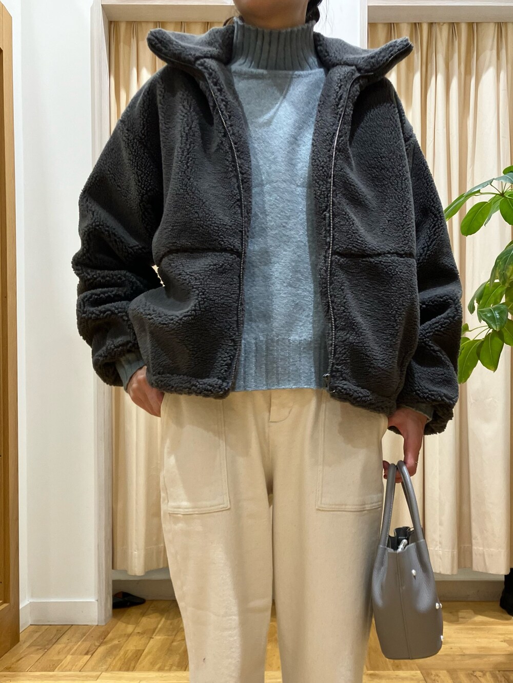 グレー系のその他アウター、グリーン系のニット/セーター、ホワイト系のその他パンツを着用したレディースの冬コーディネートの3枚目の写真