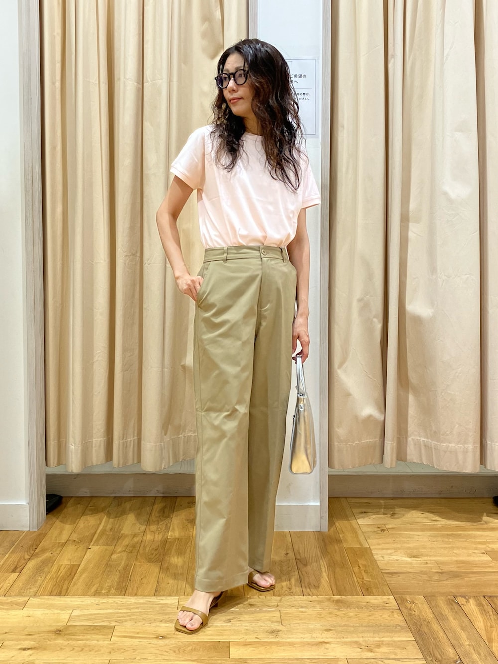 ピンク系のTシャツ/カットソー、ベージュ系のその他パンツ、イエロー系のサンダルを着用したレディースの夏コーディネートの2枚目の写真