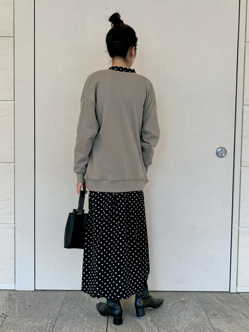 グリーン系のカーディガン/ボレロ、ブラック系のワンピース、ブラック系のハンドバッグを着用したレディースの秋コーディネートの3枚目の写真