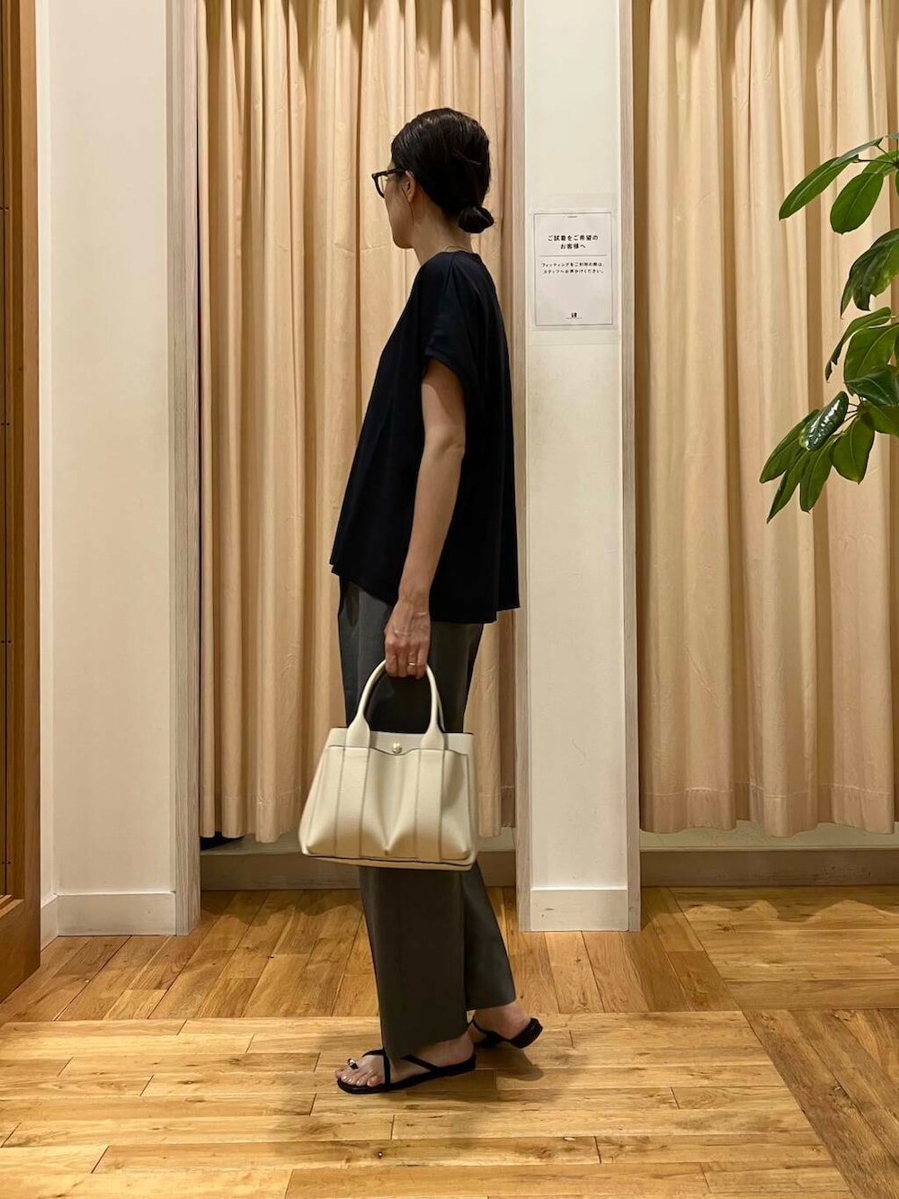 ホワイト系のトートバッグ、グレー系のその他パンツ、ブラック系のサンダルを着用したレディースの夏コーディネートの3枚目の写真