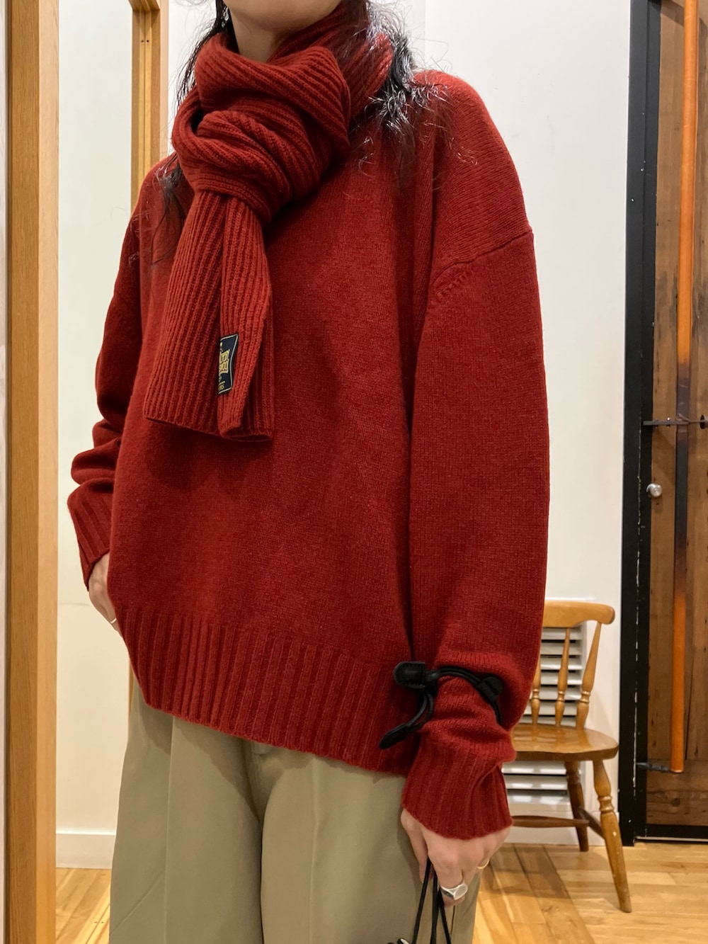 ベージュ系のその他パンツ、ブラック系のショルダーバッグ、レッド系のニット/セーターを着用したレディースの秋コーディネートの3枚目の写真