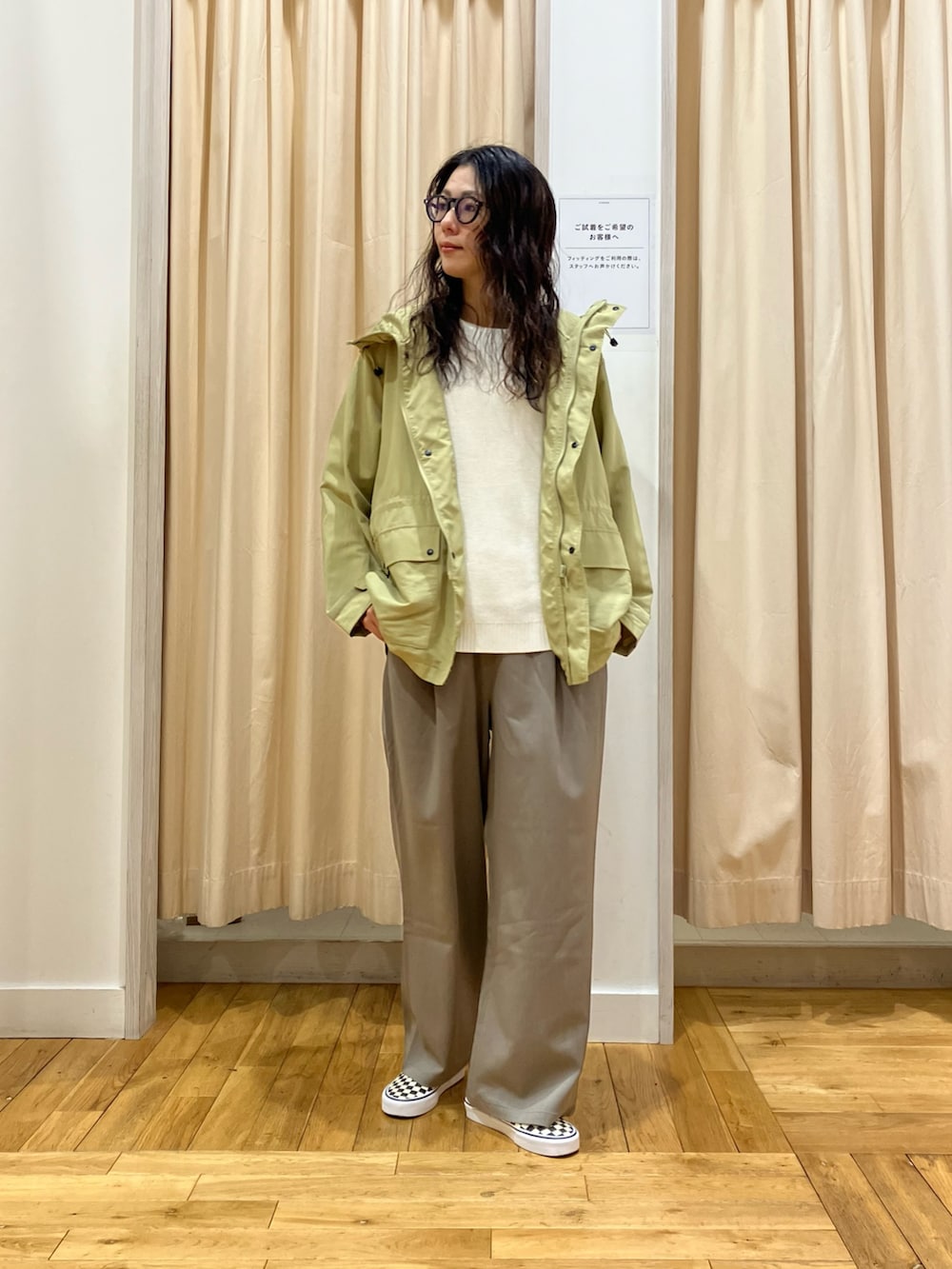 ホワイト系のニット/セーター、グリーン系のマウンテンパーカー、グレー系のその他パンツを着用したレディースの春コーディネートの2枚目の写真