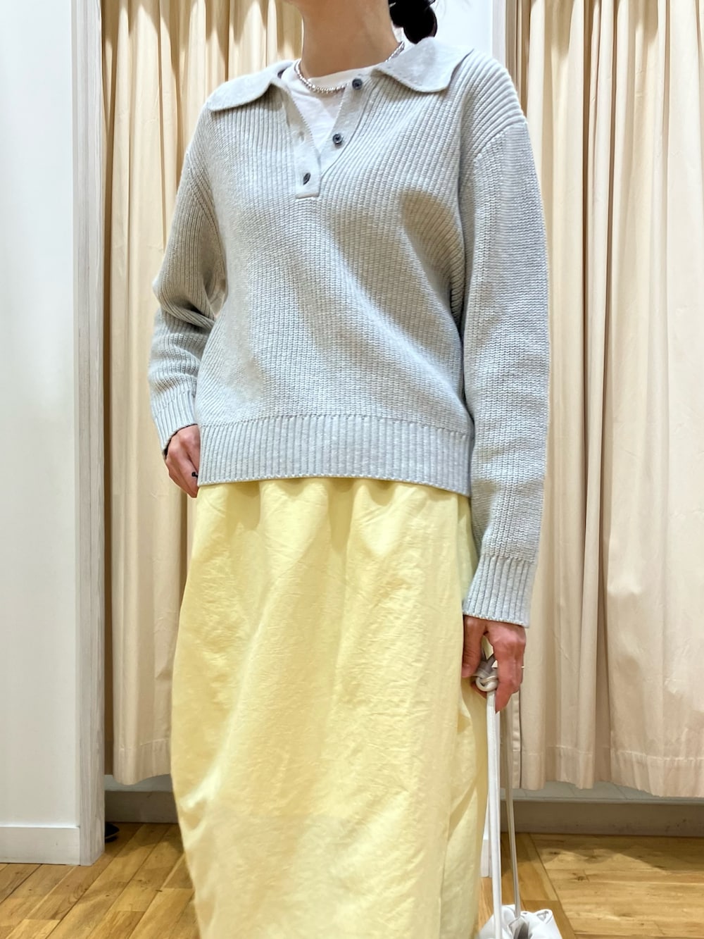 グレー系のニット/セーター、イエロー系のスカート、グレー系のスニーカーを着用したレディースの冬コーディネートの5枚目の写真