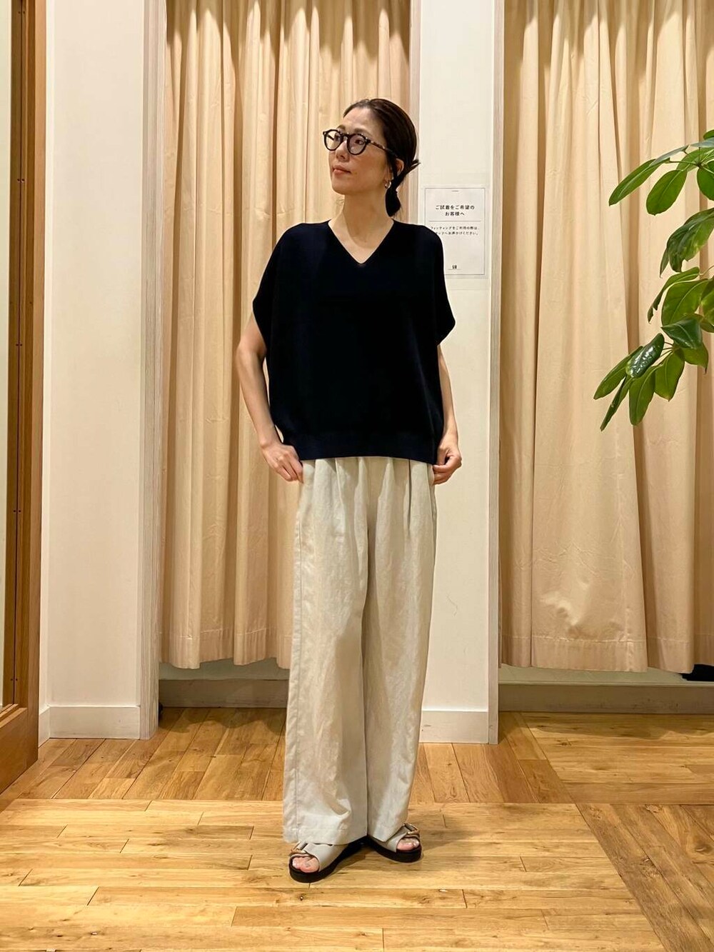 グレー系のサンダル、ベージュ系のその他パンツ、ブルー系のニット/セーターを着用したレディースの夏コーディネートの2枚目の写真