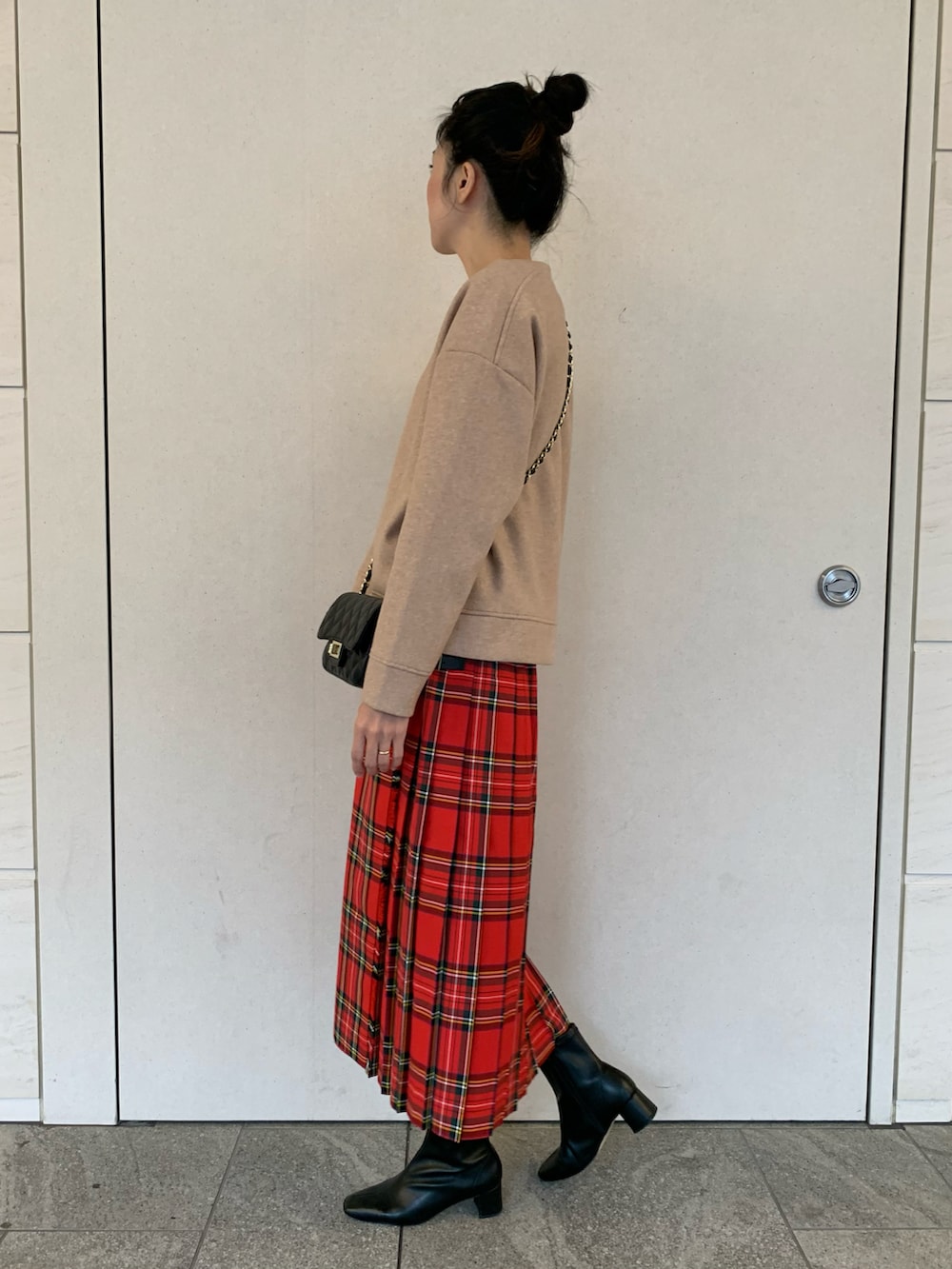 オレンジ系のカーディガン/ボレロ、レッド系のスカート、ブラック系のショルダーバッグを着用したレディースの秋コーディネートの2枚目の写真