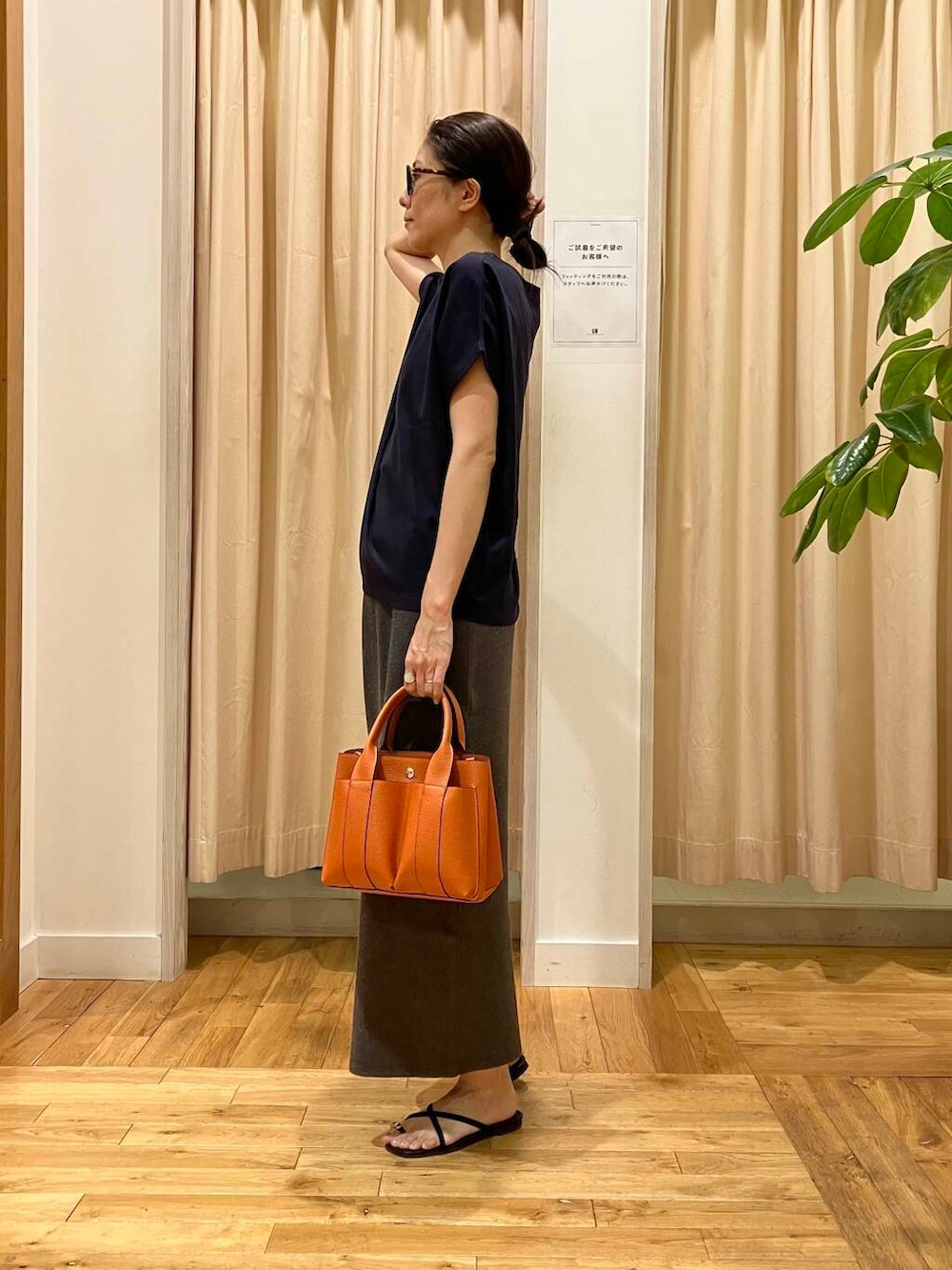 ブルー系のTシャツ/カットソー、グレー系のスカート、オレンジ系のトートバッグを着用したレディースの夏コーディネートの2枚目の写真