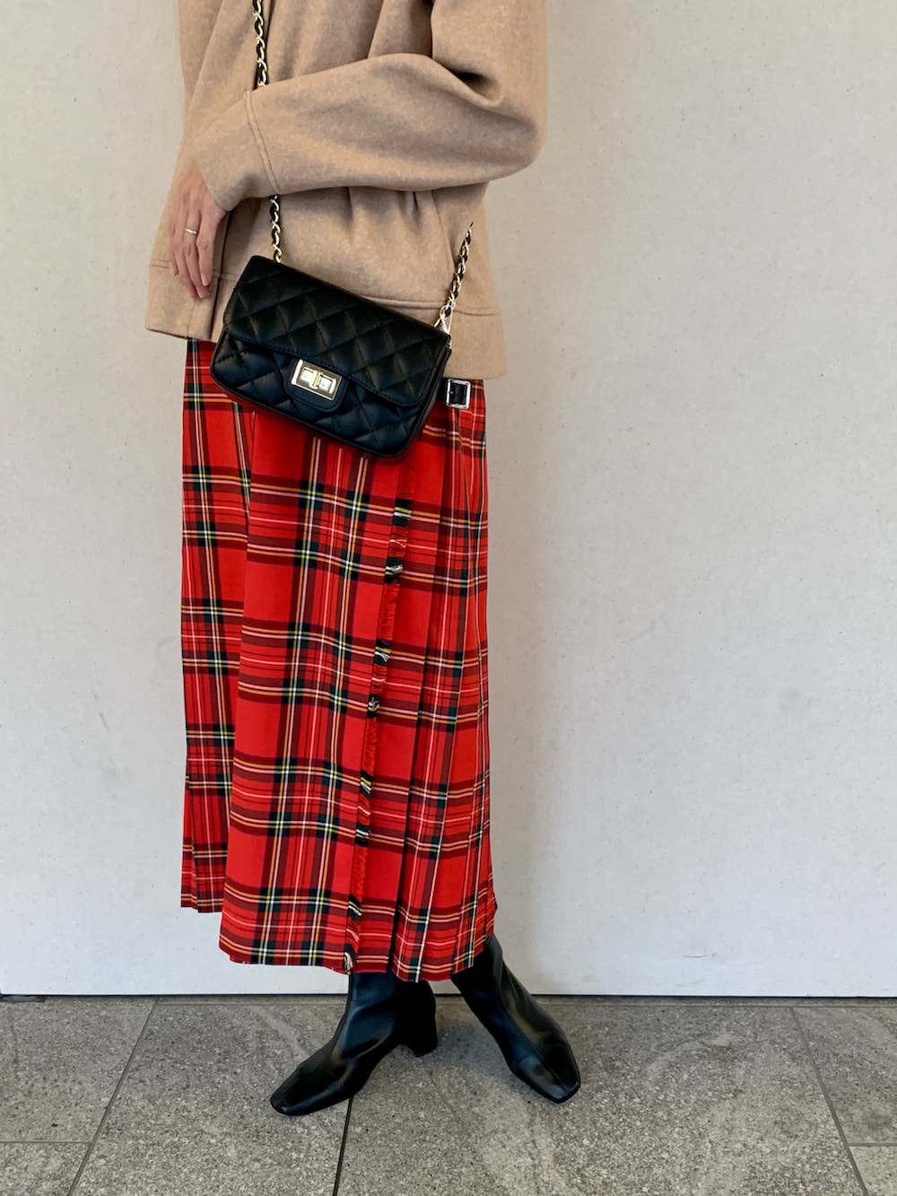 オレンジ系のカーディガン/ボレロ、レッド系のスカート、ブラック系のショルダーバッグを着用したレディースの秋コーディネートの4枚目の写真