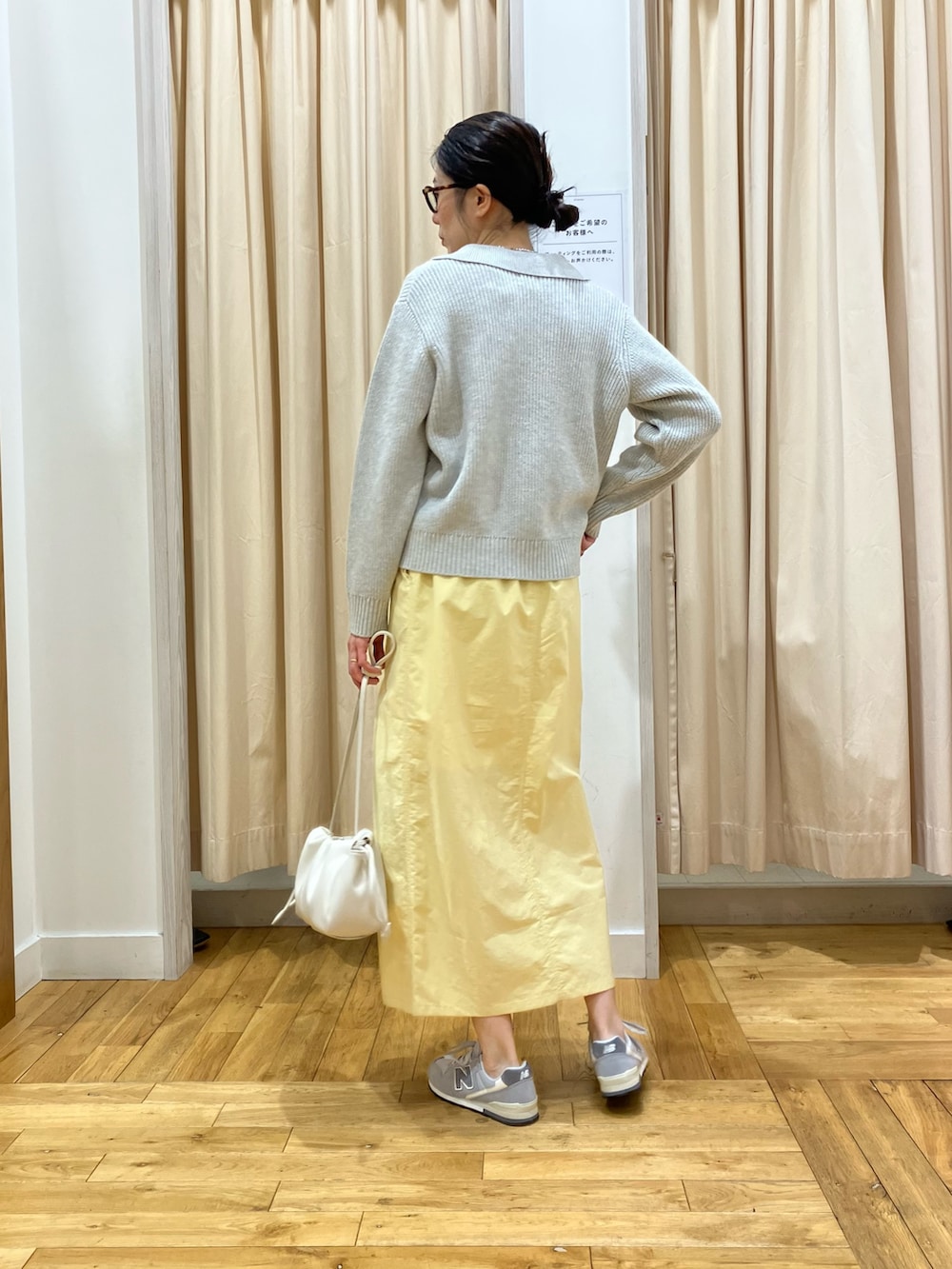 グレー系のニット/セーター、イエロー系のスカート、グレー系のスニーカーを着用したレディースの冬コーディネートの4枚目の写真