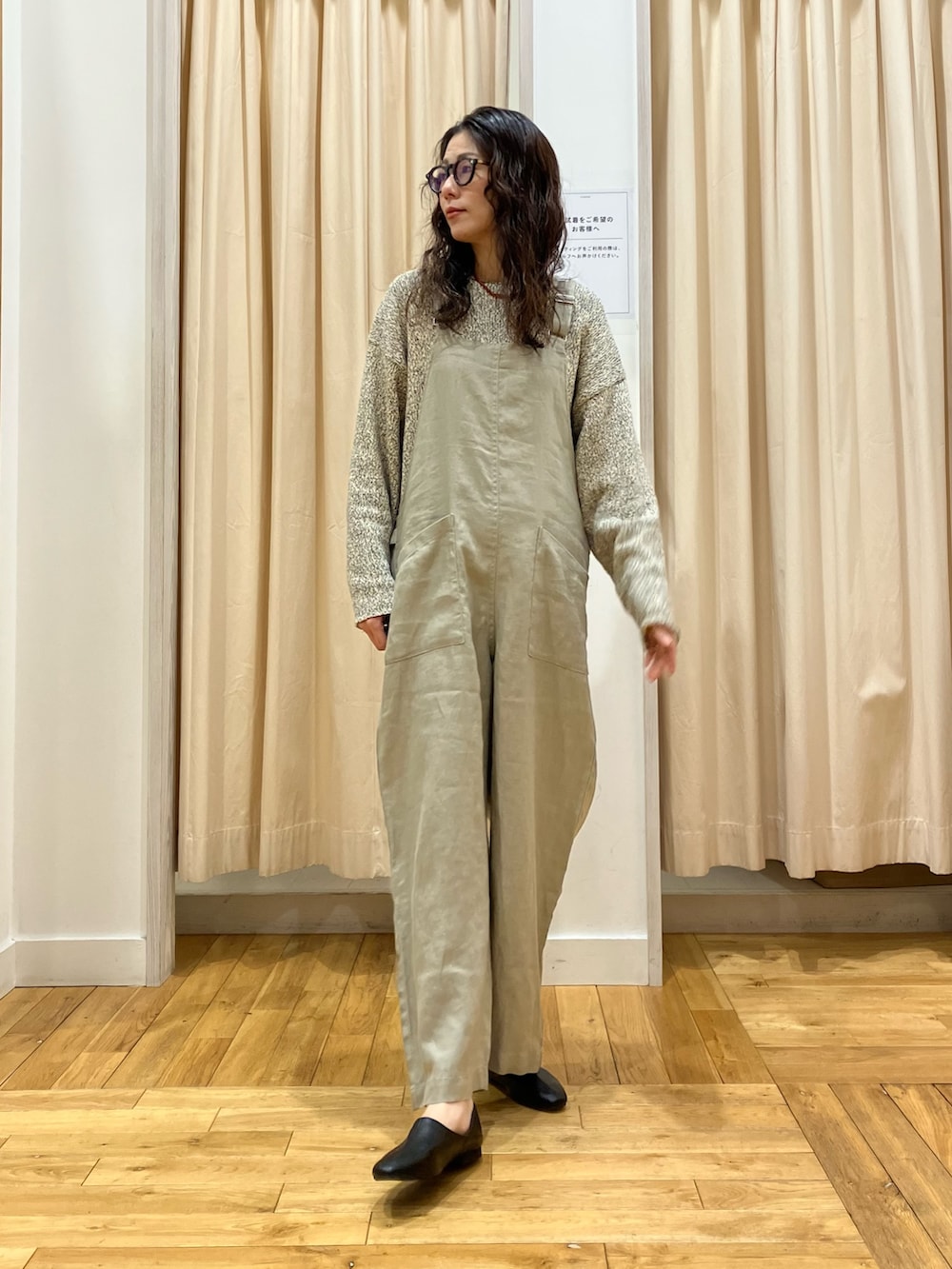 ベージュ系のニット/セーター、ブラック系のその他シューズ、グレー系のサロペット/オーバーオールを着用したレディースの冬コーディネートの2枚目の写真