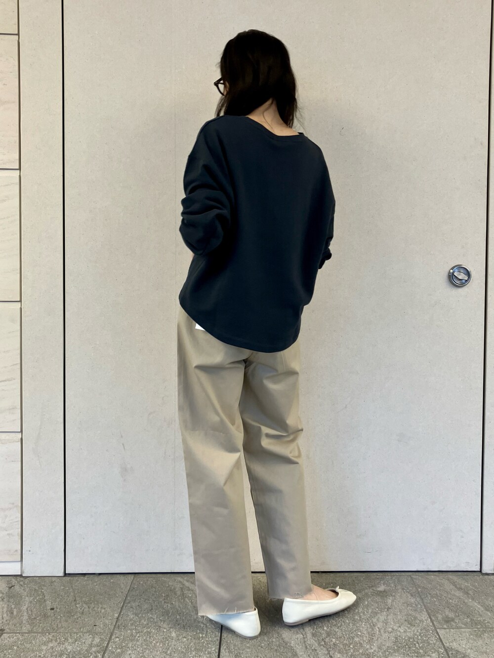 ブルー系のスウェット、ベージュ系のチノパンツ、ホワイト系のバレエシューズを着用したレディースの春コーディネートの4枚目の写真