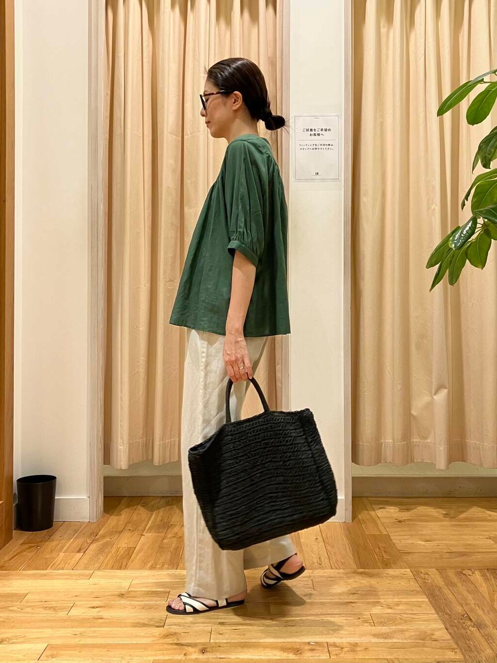 ブラック系のトートバッグ、ホワイト系のサンダル、ベージュ系のその他パンツを着用したレディースの夏コーディネートの3枚目の写真