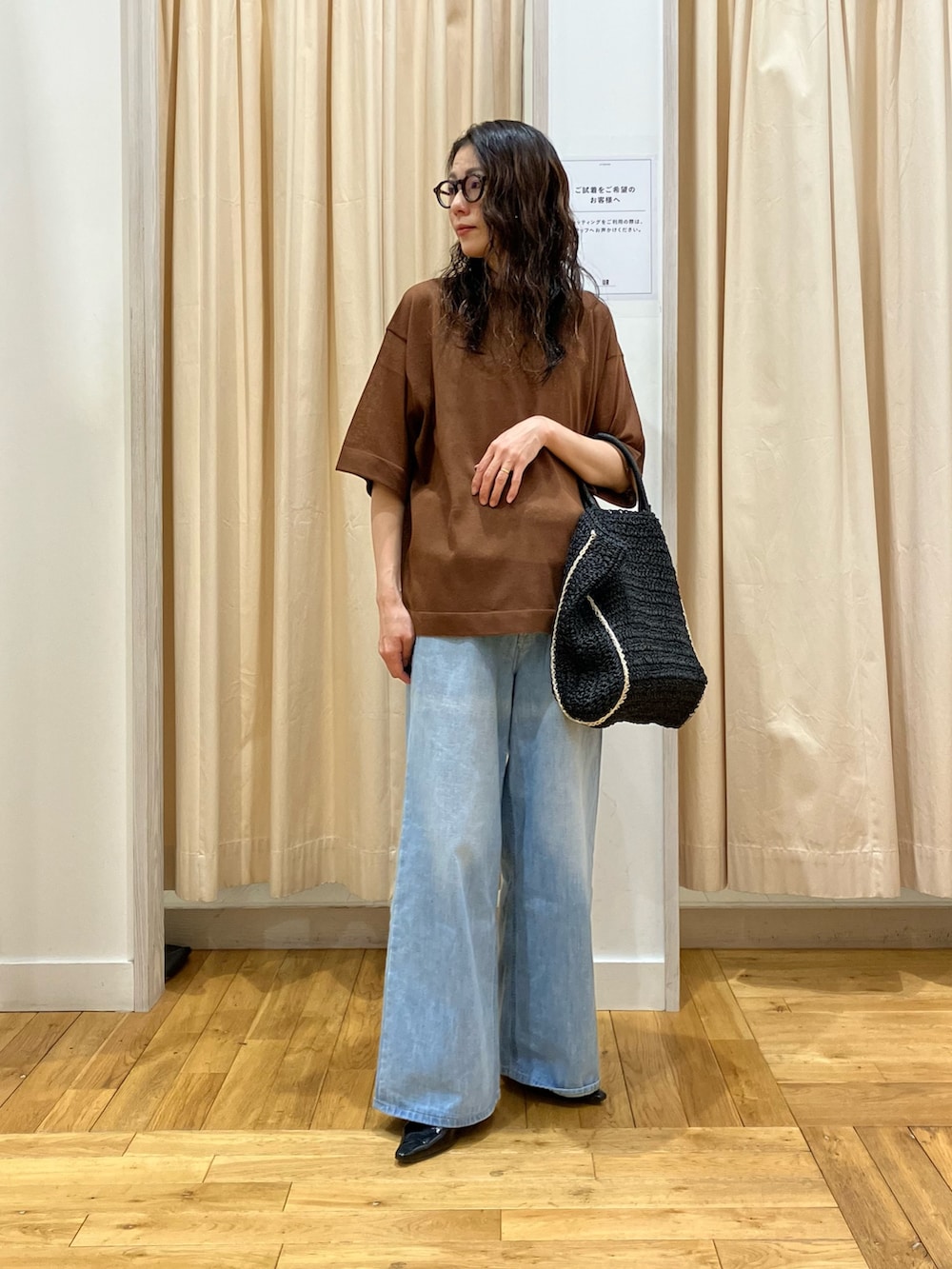 イエロー系のニット/セーター、ブルー系のデニムパンツを着用したレディースの春コーディネートの2枚目の写真