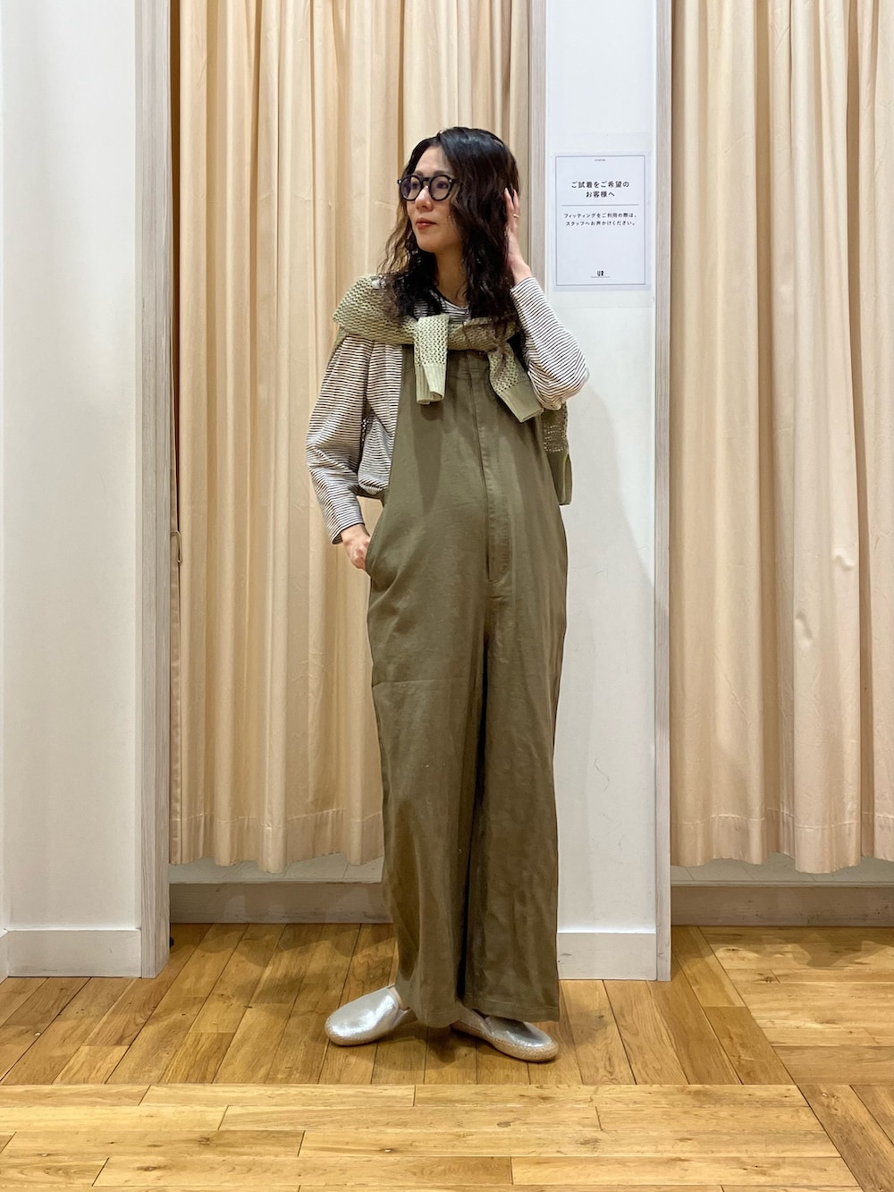 グリーン系のサロペット/オーバーオール、ベージュ系のTシャツ/カットソー、グリーン系のニット/セーターを着用したレディースの春コーディネートの2枚目の写真