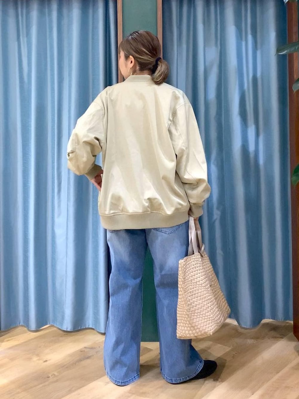 ブルー系のデニムパンツ、ベージュ系のMA-1、グリーン系のTシャツ/カットソーを着用したレディースの冬コーディネートの6枚目の写真