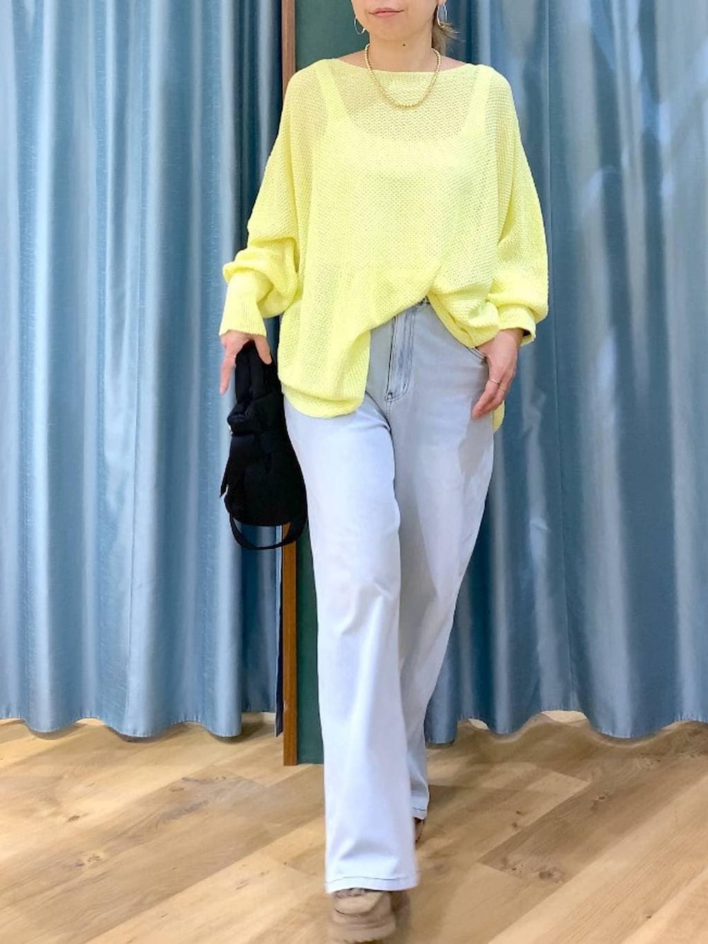 ブラック系のショルダーバッグ、ベージュ系のローファー、ブルー系のデニムパンツを着用したレディースの春コーディネートの6枚目の写真