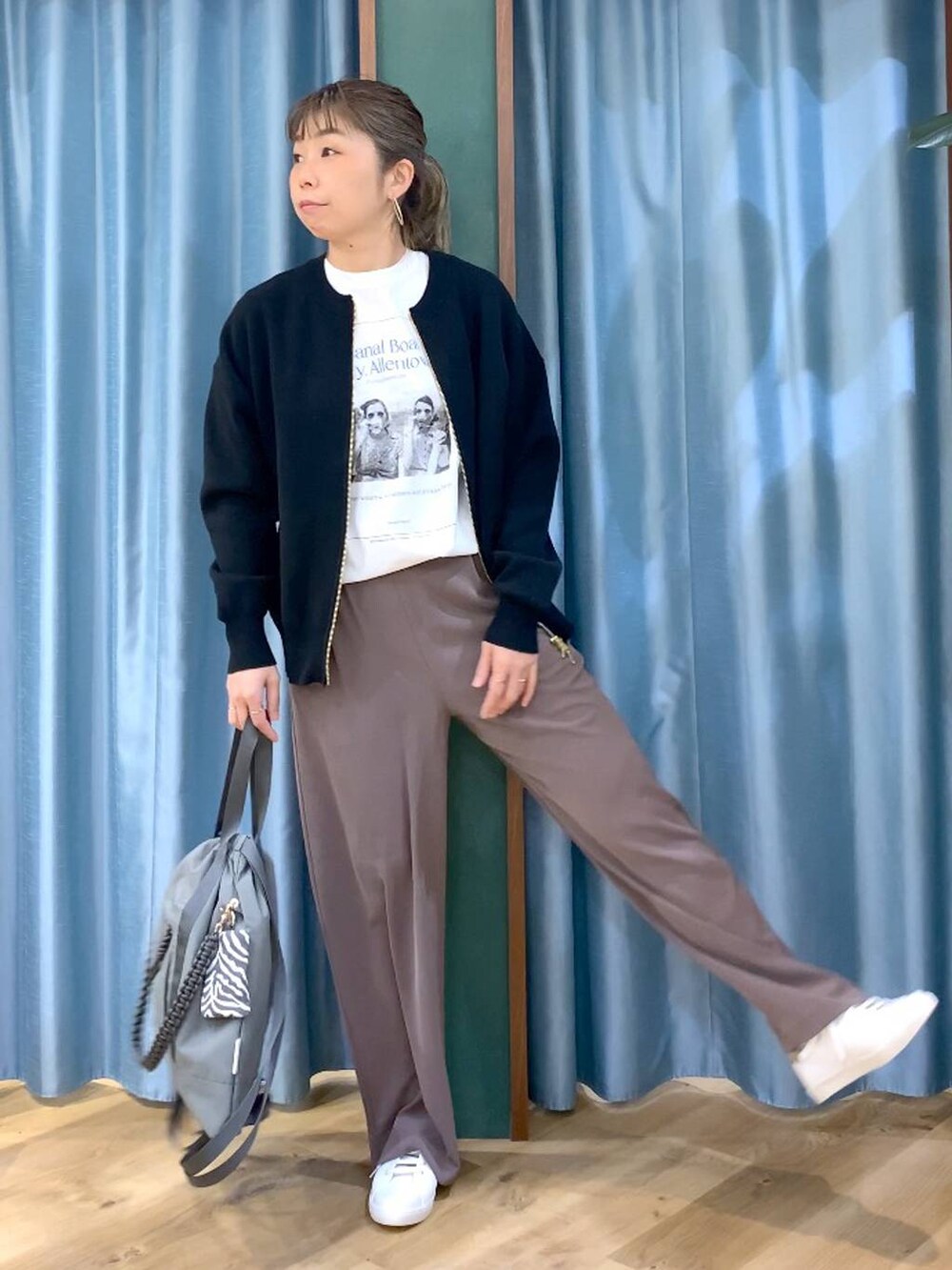 グリーン系のスラックス、ブラック系のカーディガン/ボレロ、グレー系のバックパック/リュックを着用したレディースの冬コーディネートの8枚目の写真