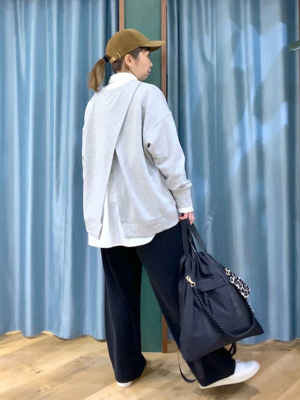 ブラック系のスラックス、グレー系のスウェット、ブラック系のバックパック/リュックを着用したレディースの冬コーディネートの5枚目の写真