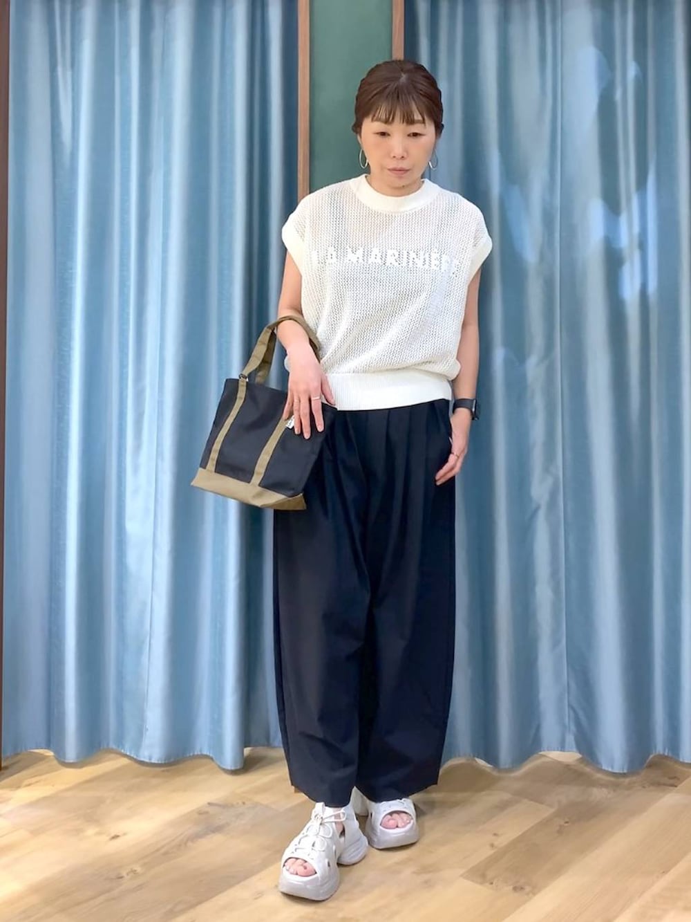 ブラウン系のタンクトップ、ホワイト系のニット/セーター、ブラック系のその他パンツを着用したレディースの春コーディネートの3枚目の写真