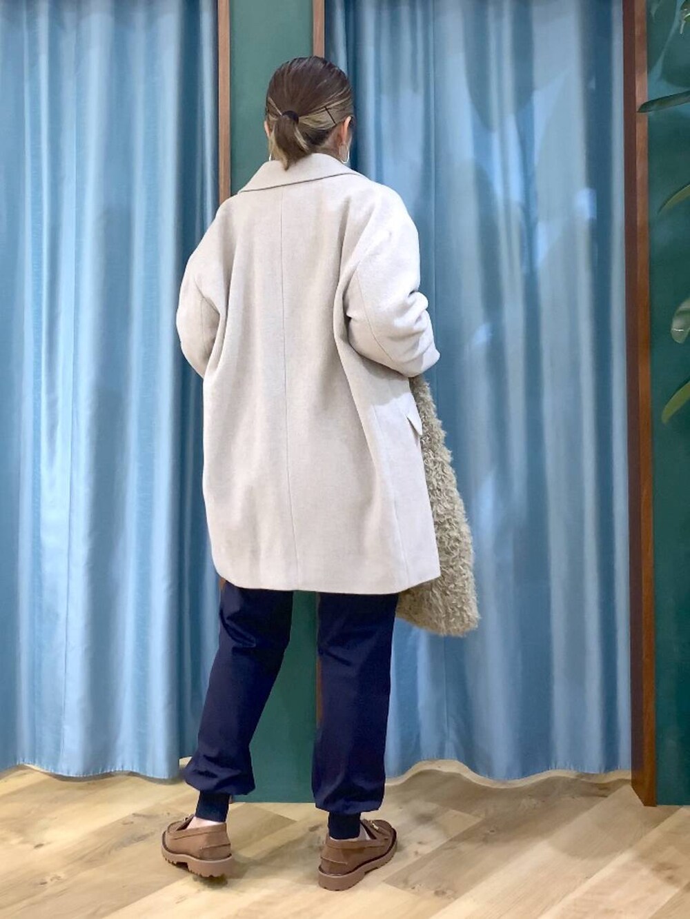 パープル系のニット/セーター、ベージュ系のピーコート、ベージュ系のハンドバッグを着用したレディースの秋コーディネートの3枚目の写真