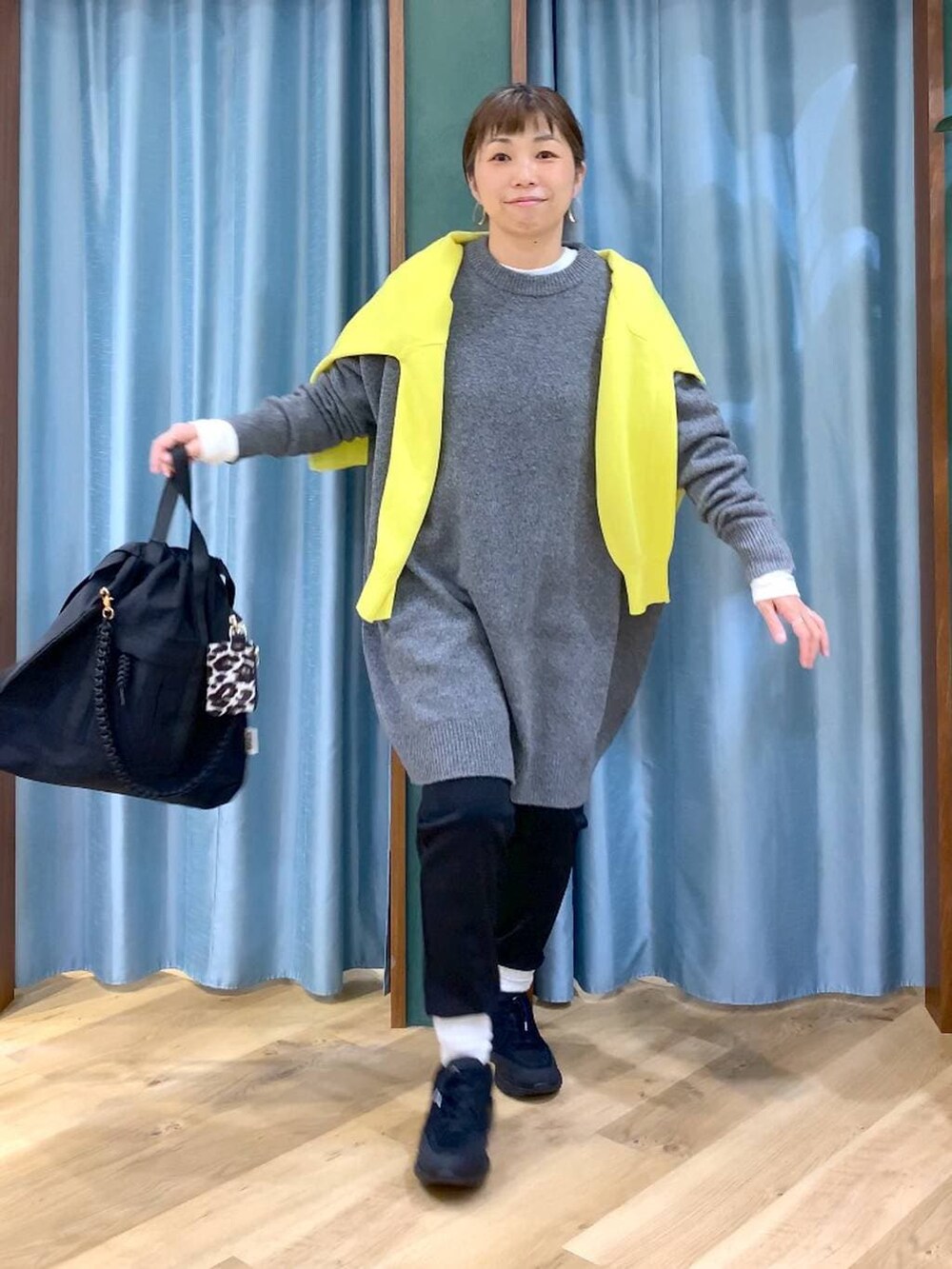 ブラック系のその他パンツ、ホワイト系のTシャツ/カットソー、イエロー系のニット/セーターを着用したレディースの秋コーディネートの4枚目の写真