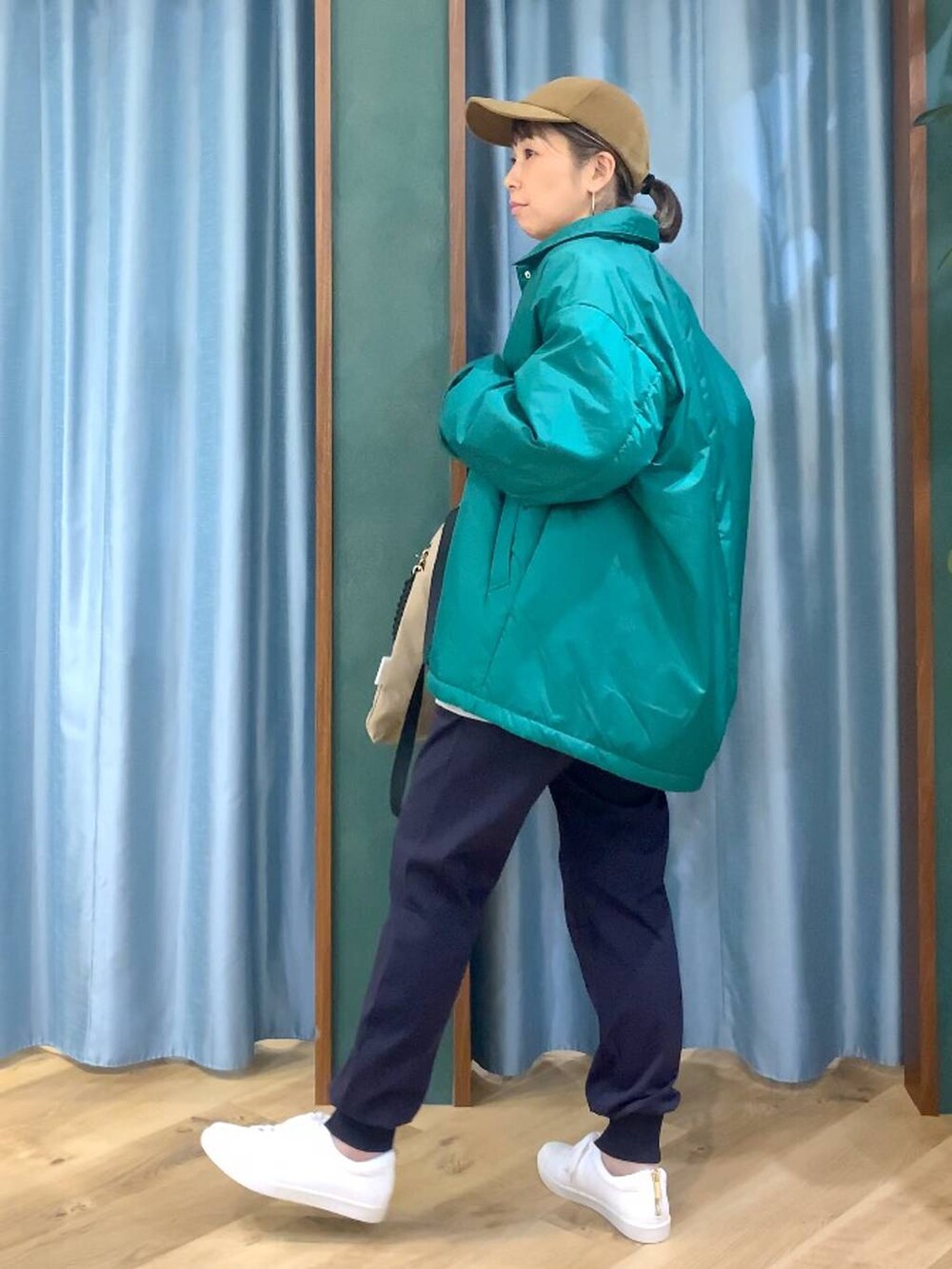 グリーン系のブルゾン、ブルー系のその他パンツ、ブラウン系のバックパック/リュックを着用したレディースの秋コーディネートの3枚目の写真