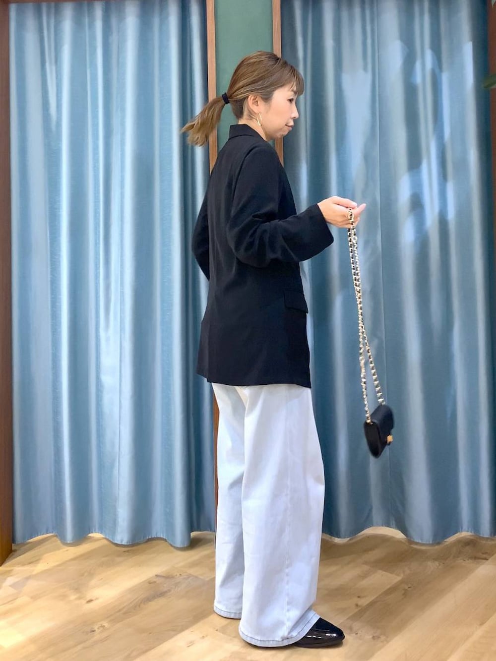 ホワイト系のその他トップス、ブルー系のデニムパンツ、ブラック系のテーラードジャケットを着用したレディースの冬コーディネートの6枚目の写真