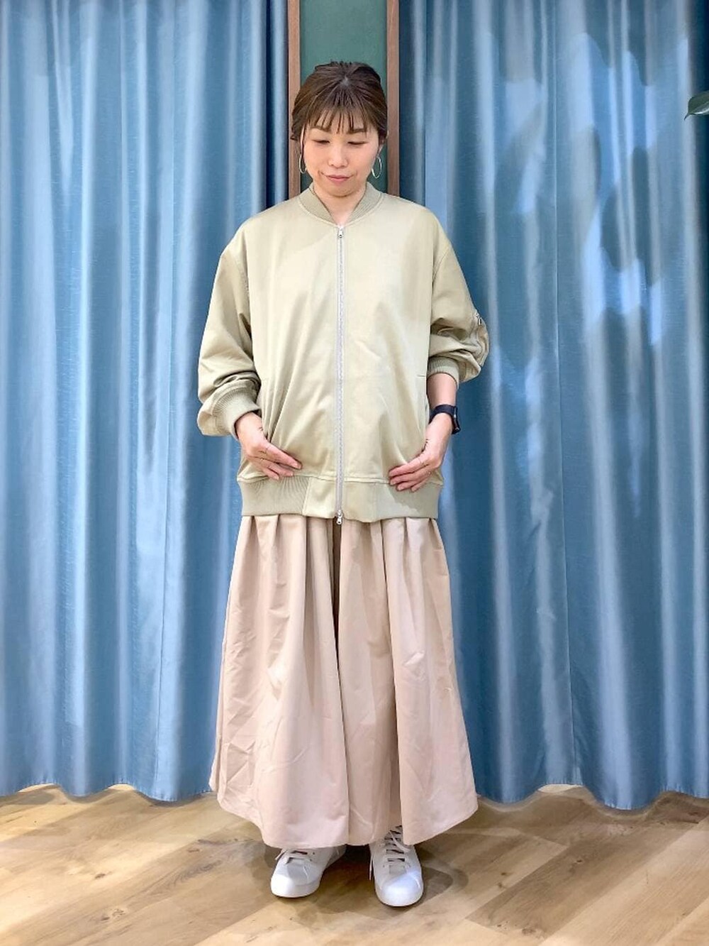 ブラウン系のショルダーバッグ、ベージュ系のスカート、ベージュ系のMA-1を着用したレディースの冬コーディネートの7枚目の写真