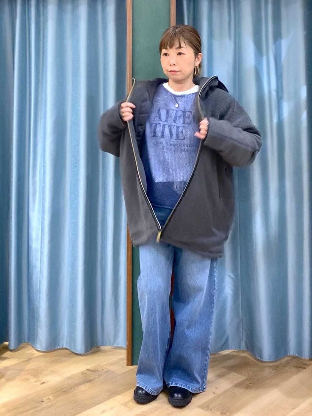 ブラック系のブーツ、ブルー系のデニムパンツ、ブルー系のニット/セーターを着用したレディースの冬コーディネートの2枚目の写真