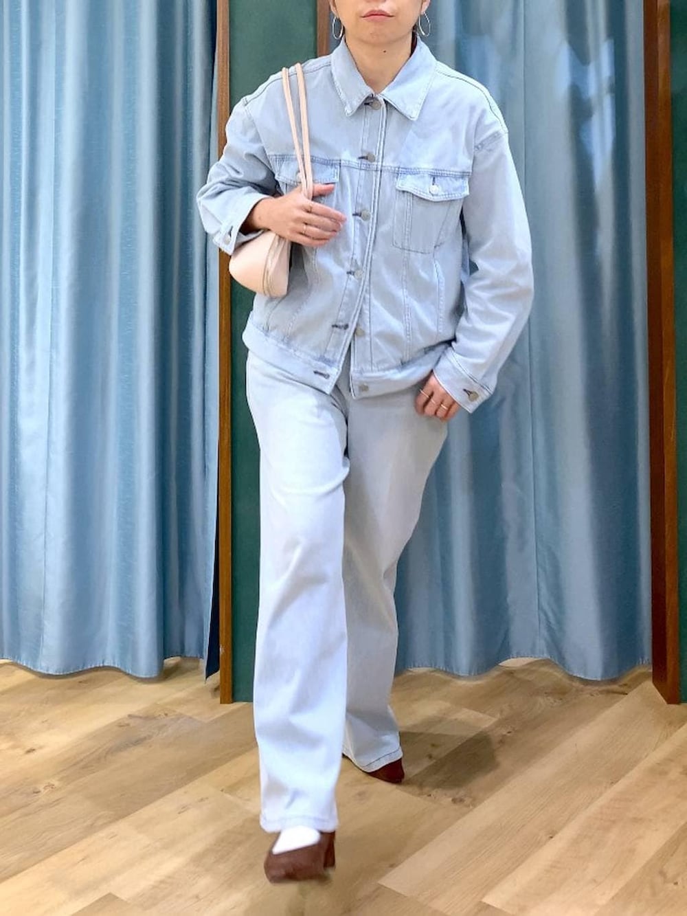 ブラウン系のパンプス、ブルー系のデニムパンツ、ブルー系のデニムジャケットを着用したレディースの春コーディネートの7枚目の写真