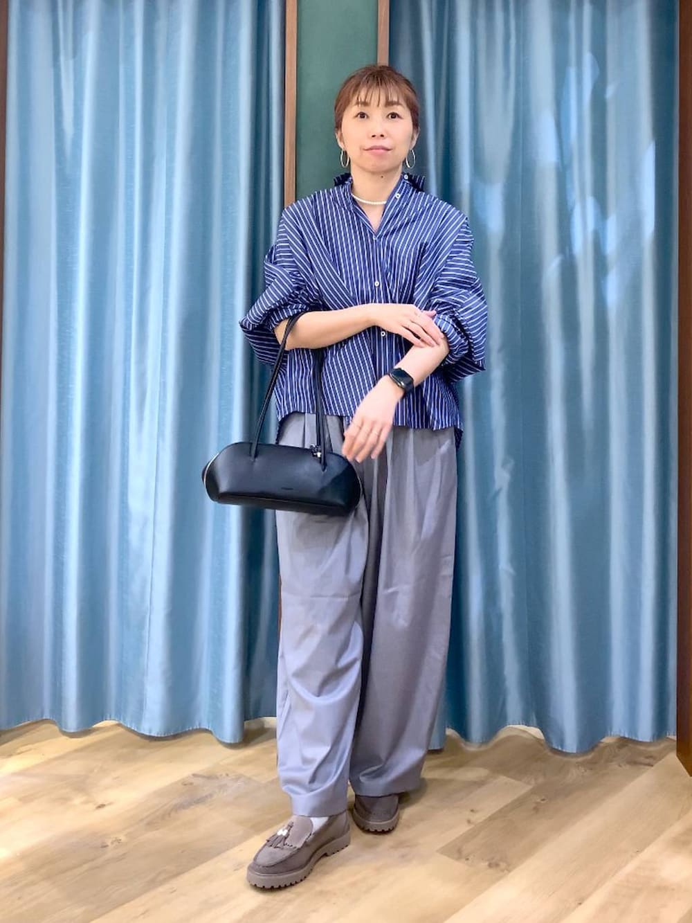 グレー系のローファー、グレー系のその他パンツ、ブルー系のシャツ/ブラウスを着用したレディースの春コーディネートの2枚目の写真